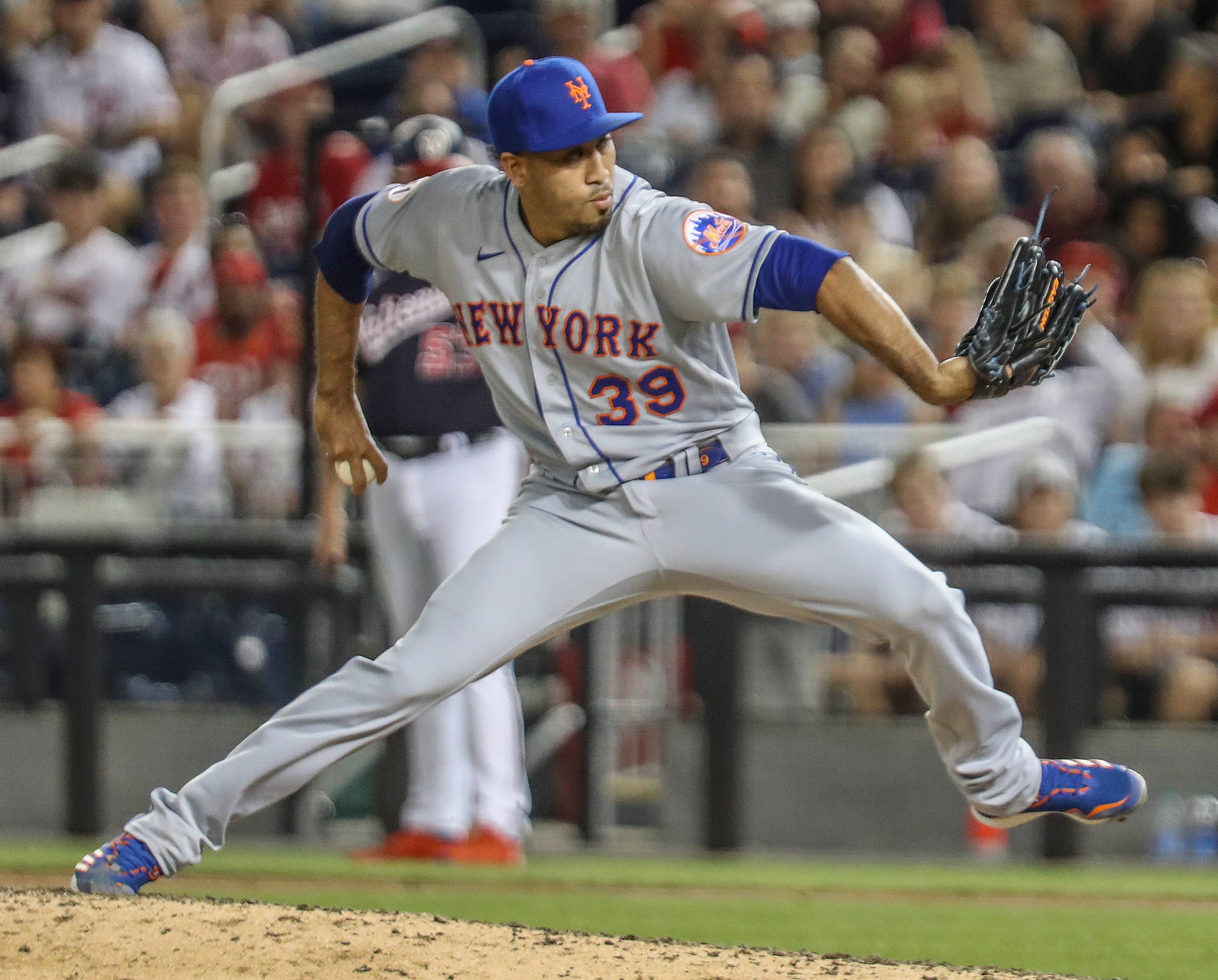 身穿灰色大都會隊服的棒球投手從投手丘投球。 — MLB 壁紙