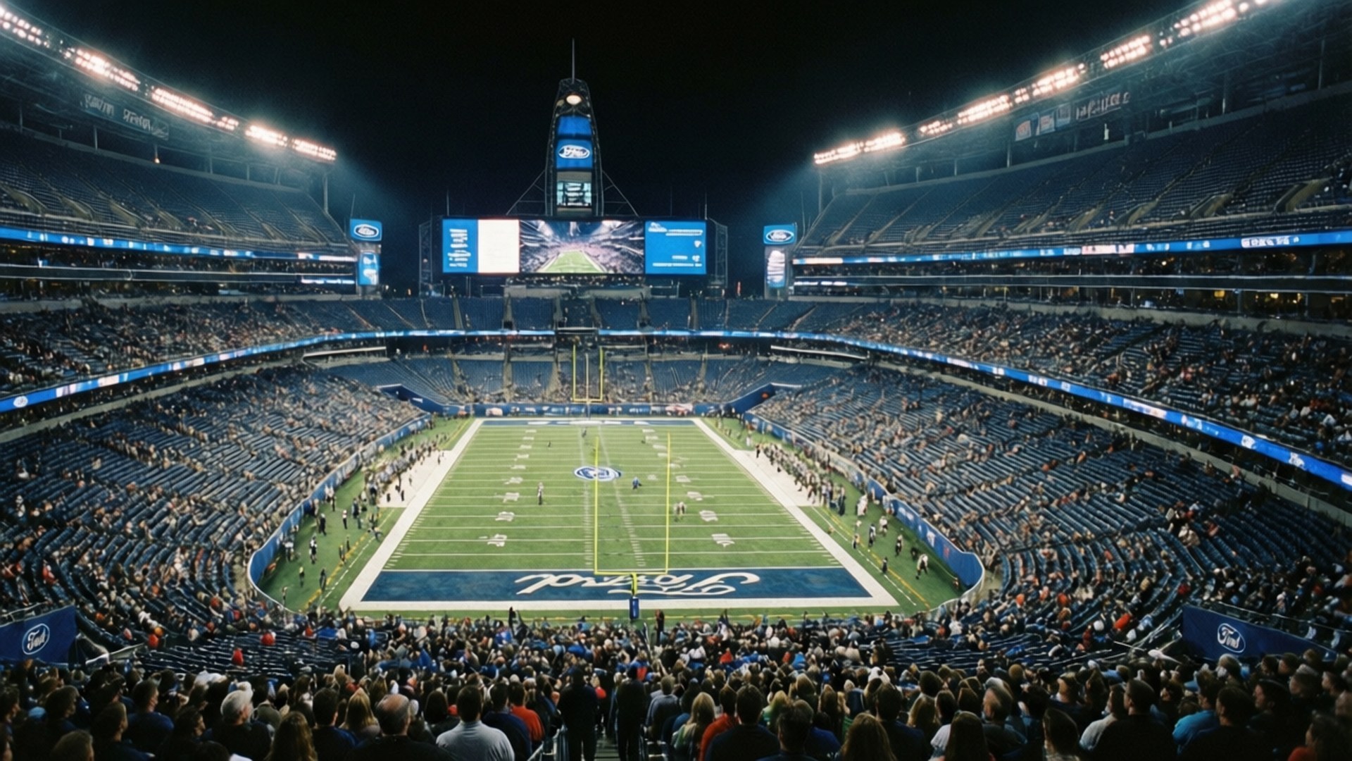 Ford Field Night Game 壁紙 — 夜晚擠滿人的足球場，明亮的燈光照亮球場和人群。