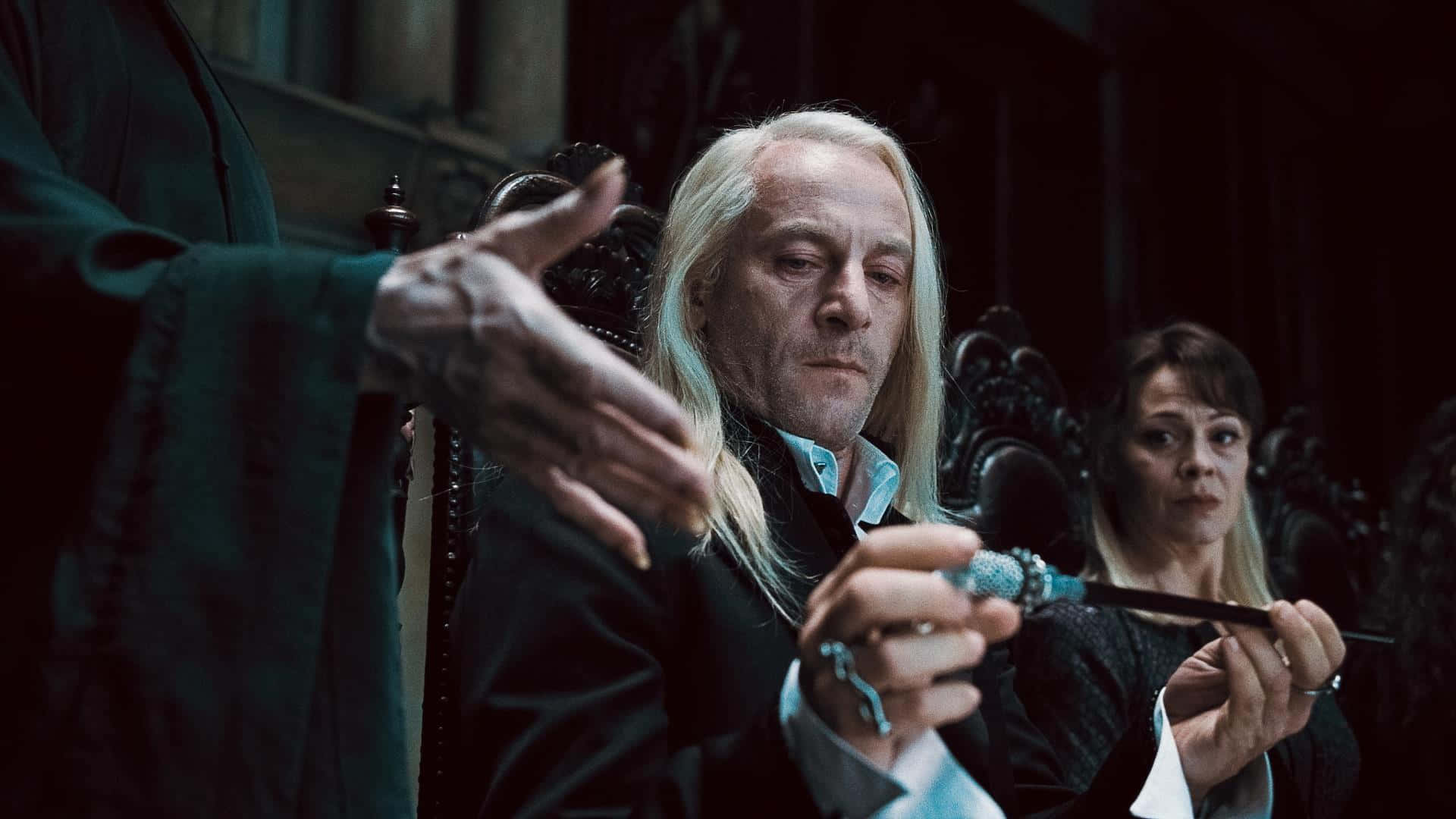  壁紙 — 一個蒼白、長白頭髮的男人拿著魔杖，而另一個人物在燈光昏暗的華麗房間裡向他做手勢。