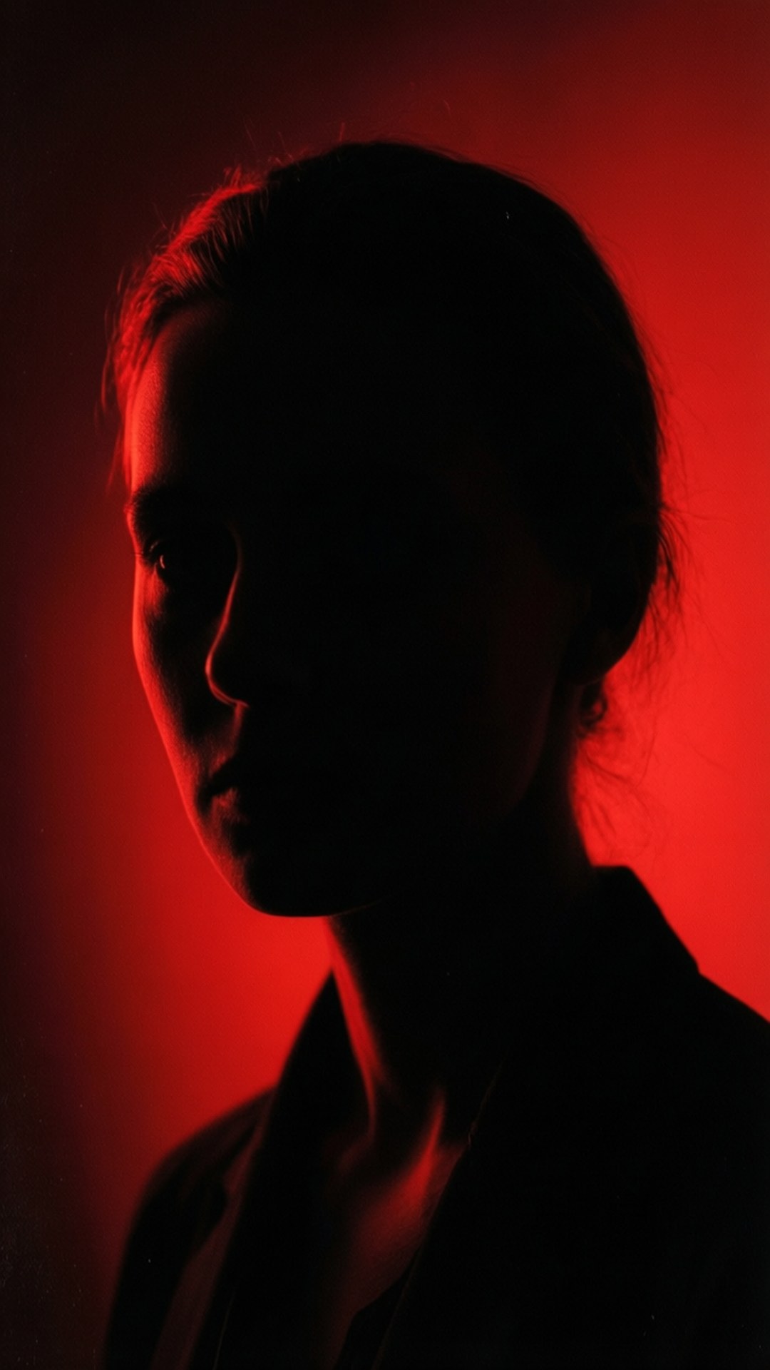 Silhouette Portrait 壁紙 — 一個人的剪影在黑暗背景下被強烈的紅光戲劇性地照亮。
