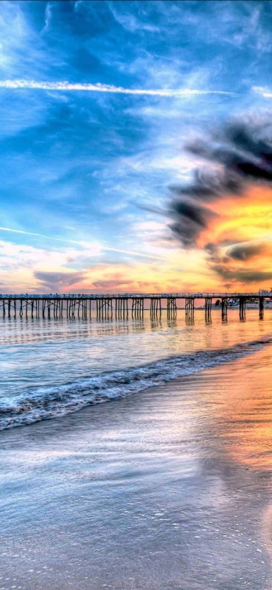 a pier with a sunset over the ocean 壁紙