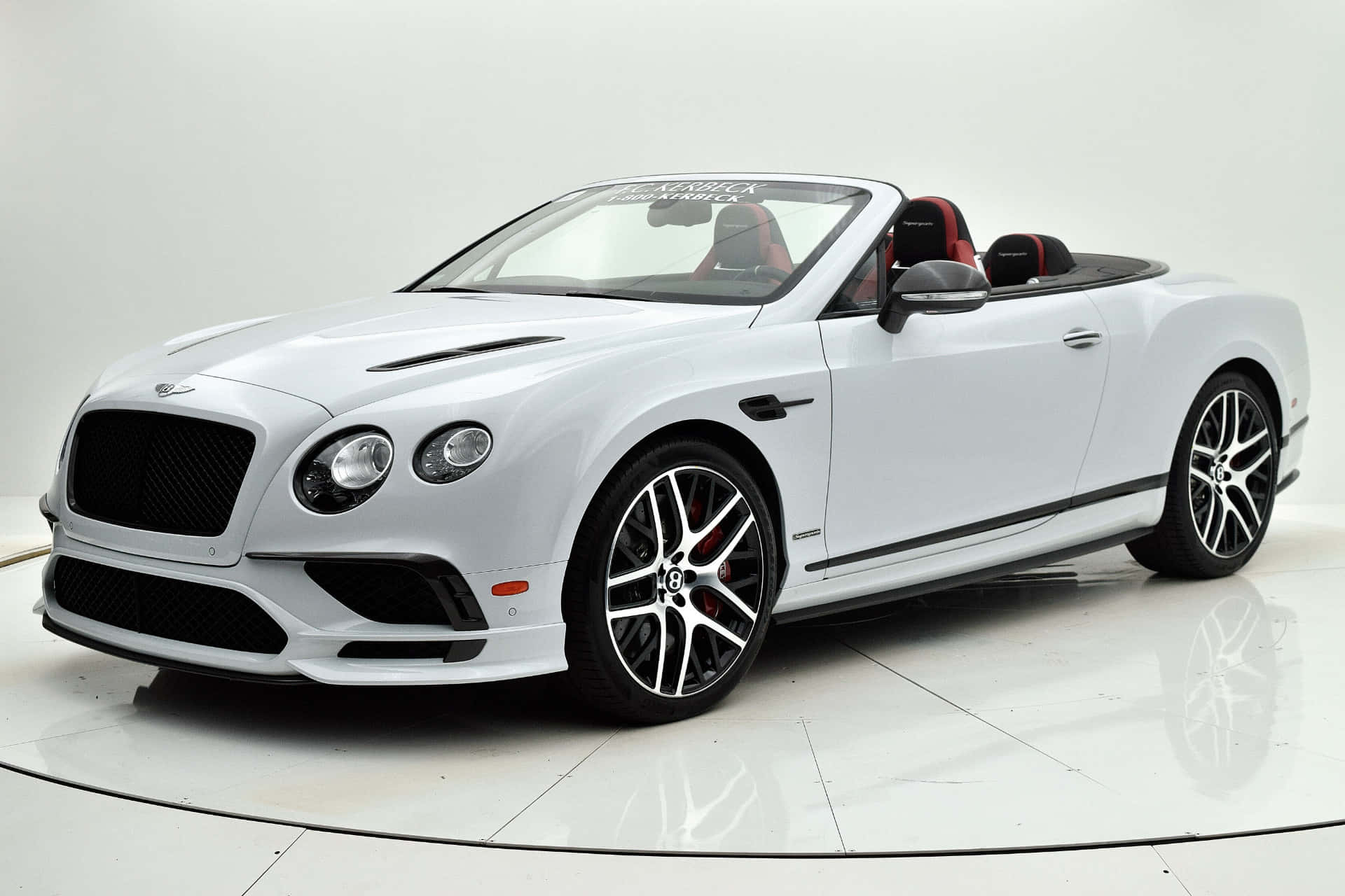 Bentley Continental Supersports 桌布 壁紙 — 一輛純白色的賓利 Continental GT 敞篷車，配備紅色內裝和黑色飾邊，在明亮的攝影棚中展示。