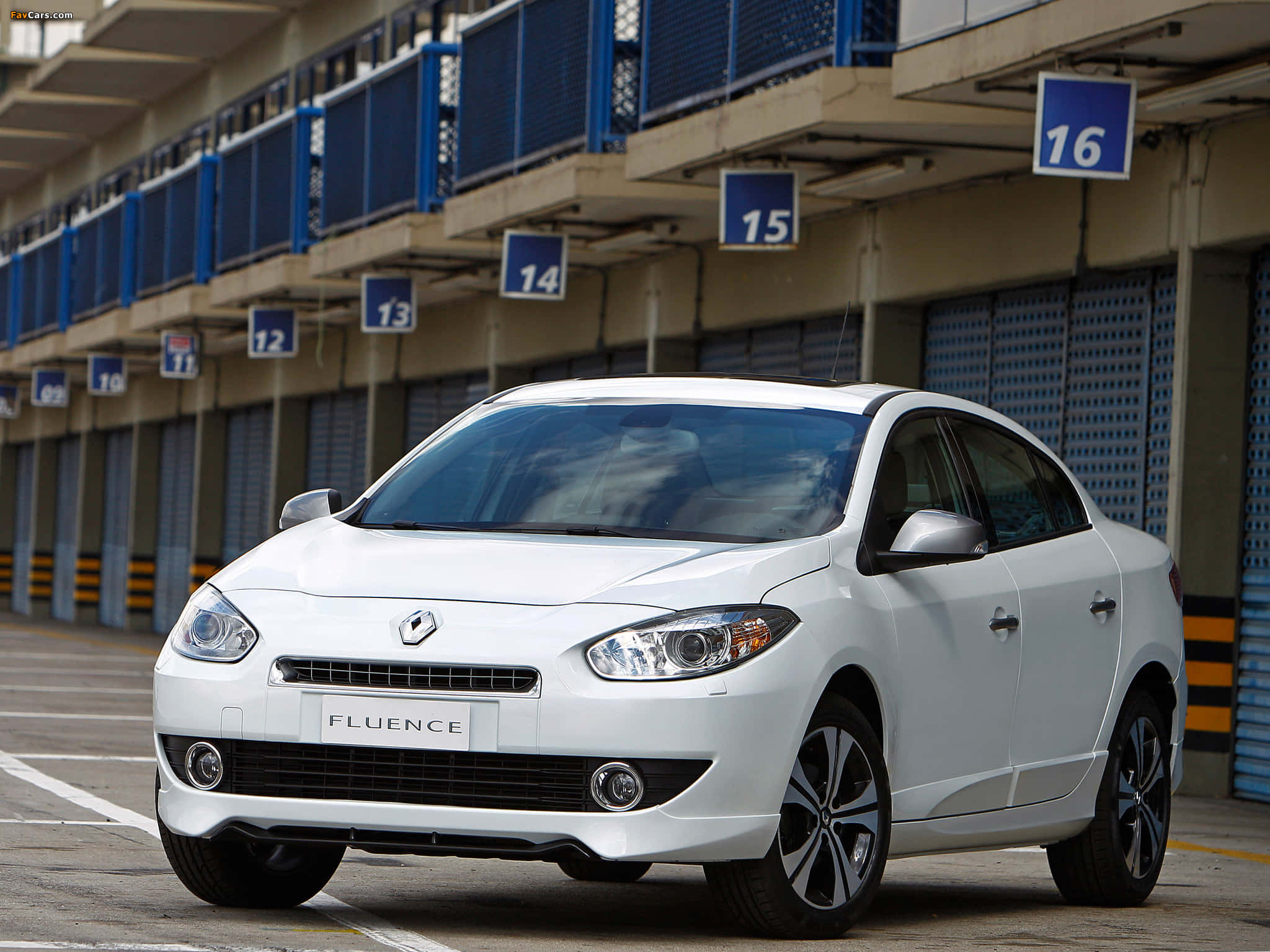 Renault Fluence 桌布 壁紙 — 一輛純白色的雷諾Fluence轎車停在一個有編號的工業車庫車位，在明亮的日光下。