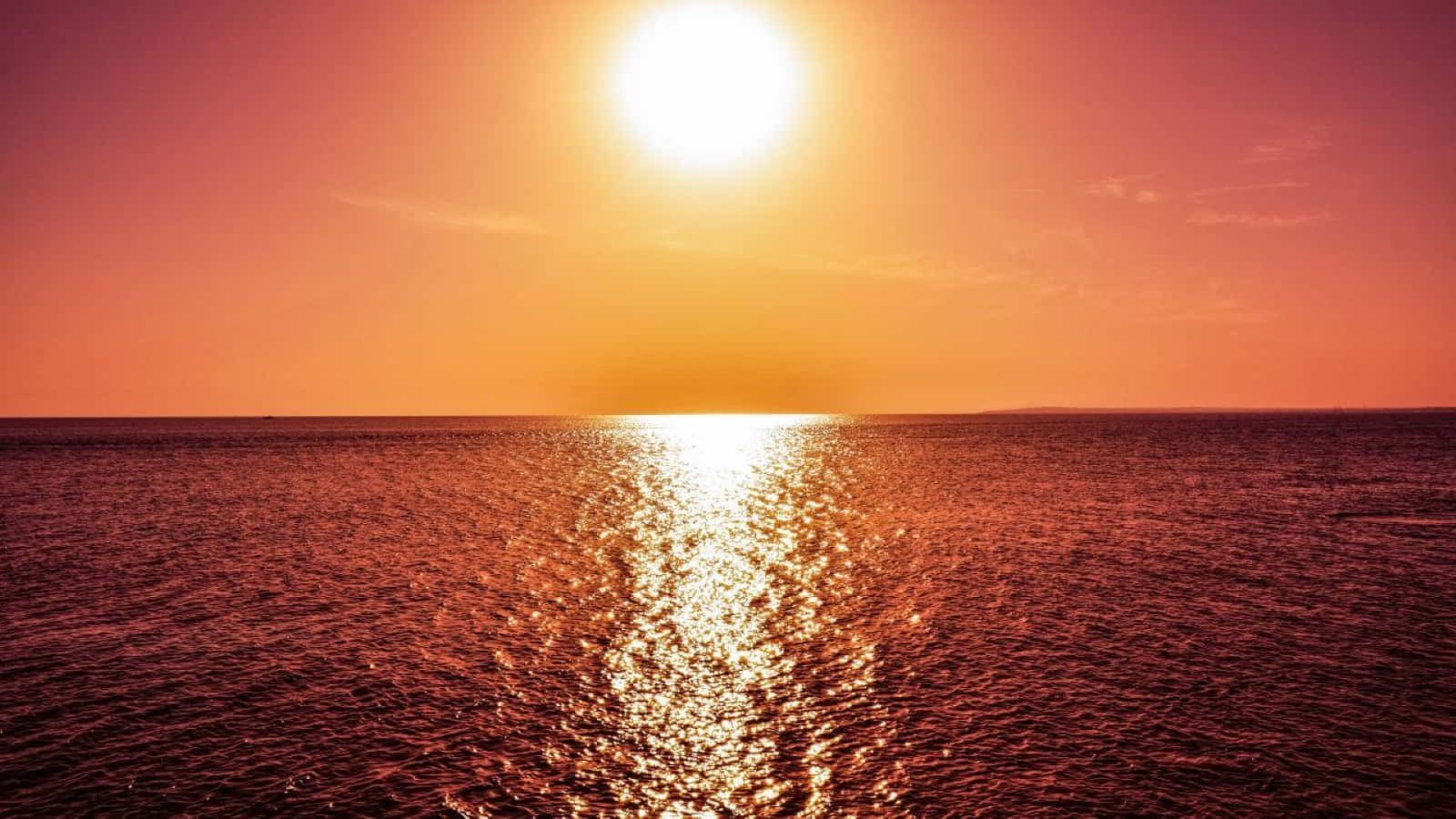 Sunset Reflection 桌布 壁紙 — 燦爛的太陽在廣闊的海洋上落下，在水面閃爍的表面上投射出火紅色的光芒。