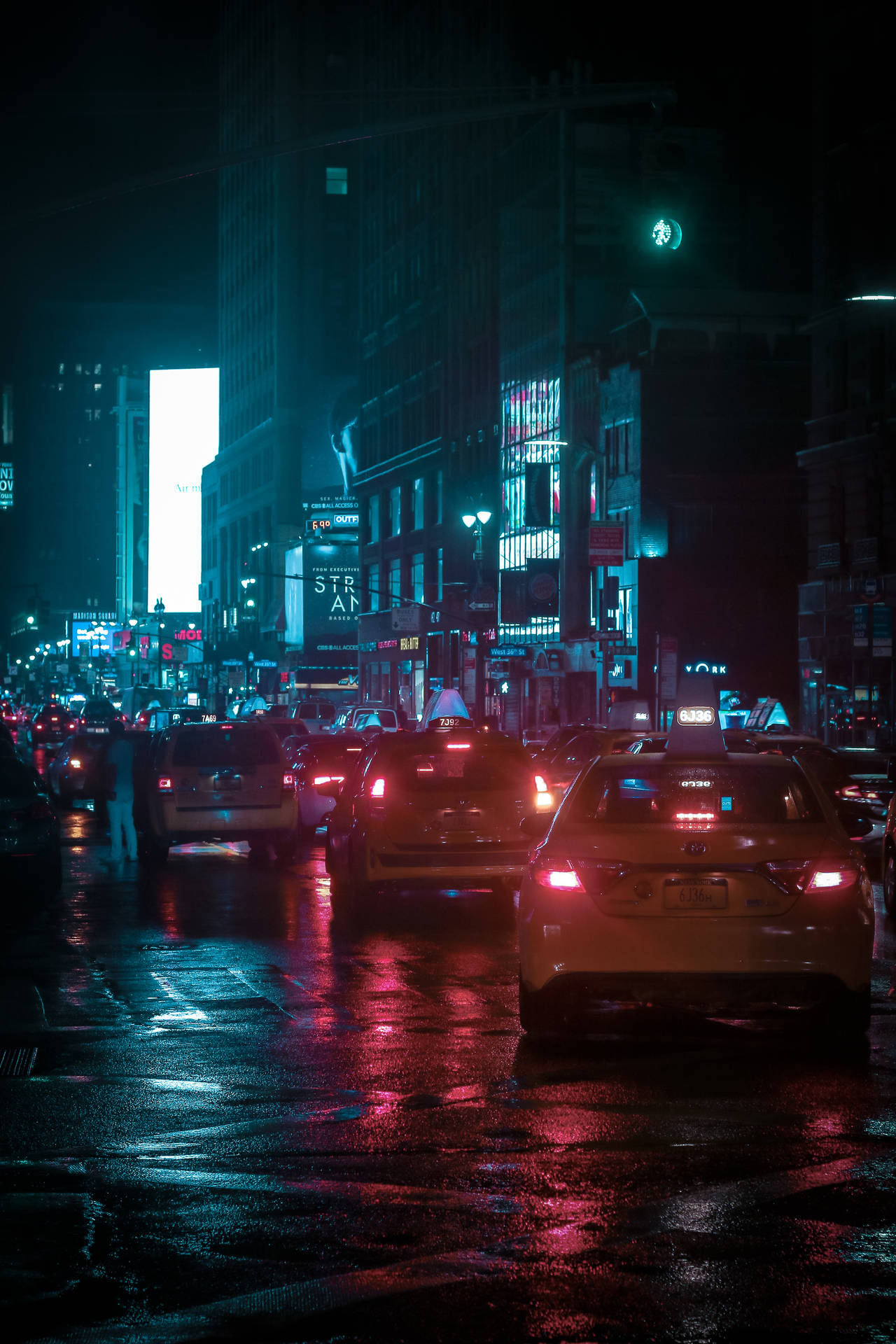 夜晚的城市街道，濕漉漉的路面反射霓虹燈光和行駛中的汽車。 — 霓虹車 壁紙