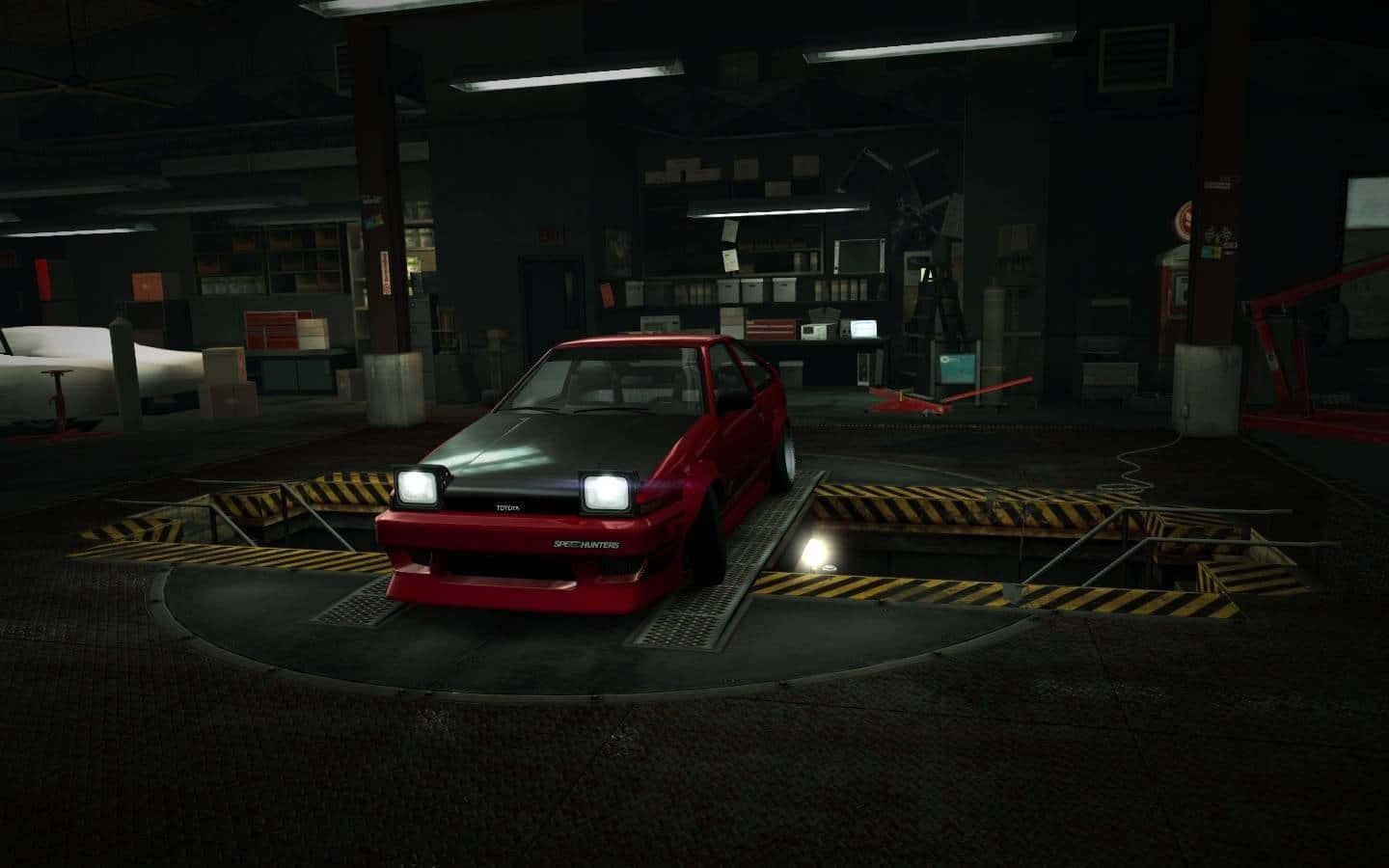  壁紙 — 一輛紅黑色的豐田AE86停放在昏暗車庫的圓形平台上，車庫內有黃色條紋坡道和頂燈。