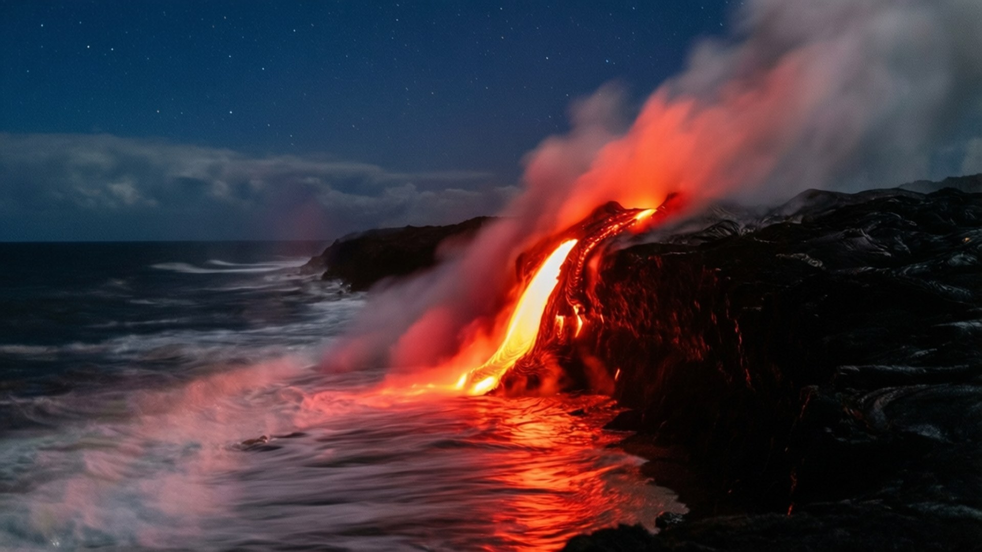 Lava Ocean Night Glow 壁紙 — 一條熔岩河流從懸崖傾瀉入夜間的大海，在星空下以火紅的光芒照亮海水。