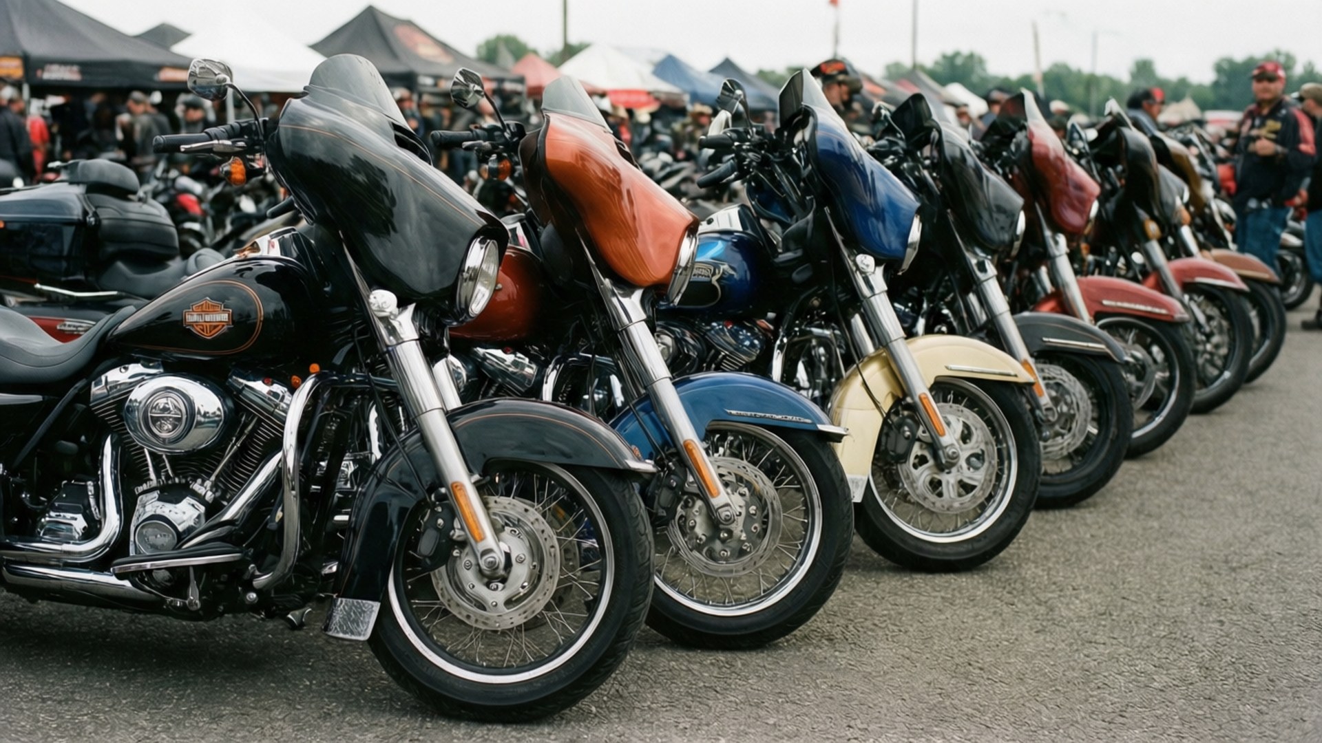 Biker Rally Lineup 壁紙 — 一排閃亮的訂製摩托車並排停放在戶外聚會中，背景有人群。