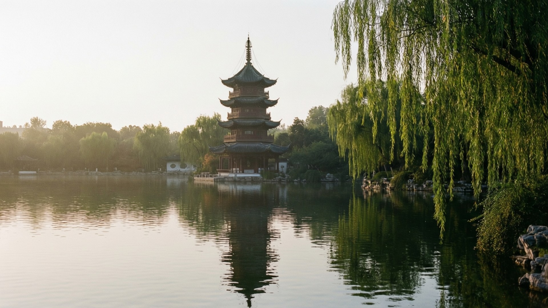 Luhu Lake Pagoda Peace 壁紙 — 一座寧靜的中國寶塔倒映在平靜的水面上，旁邊有垂柳，在黎明時分。