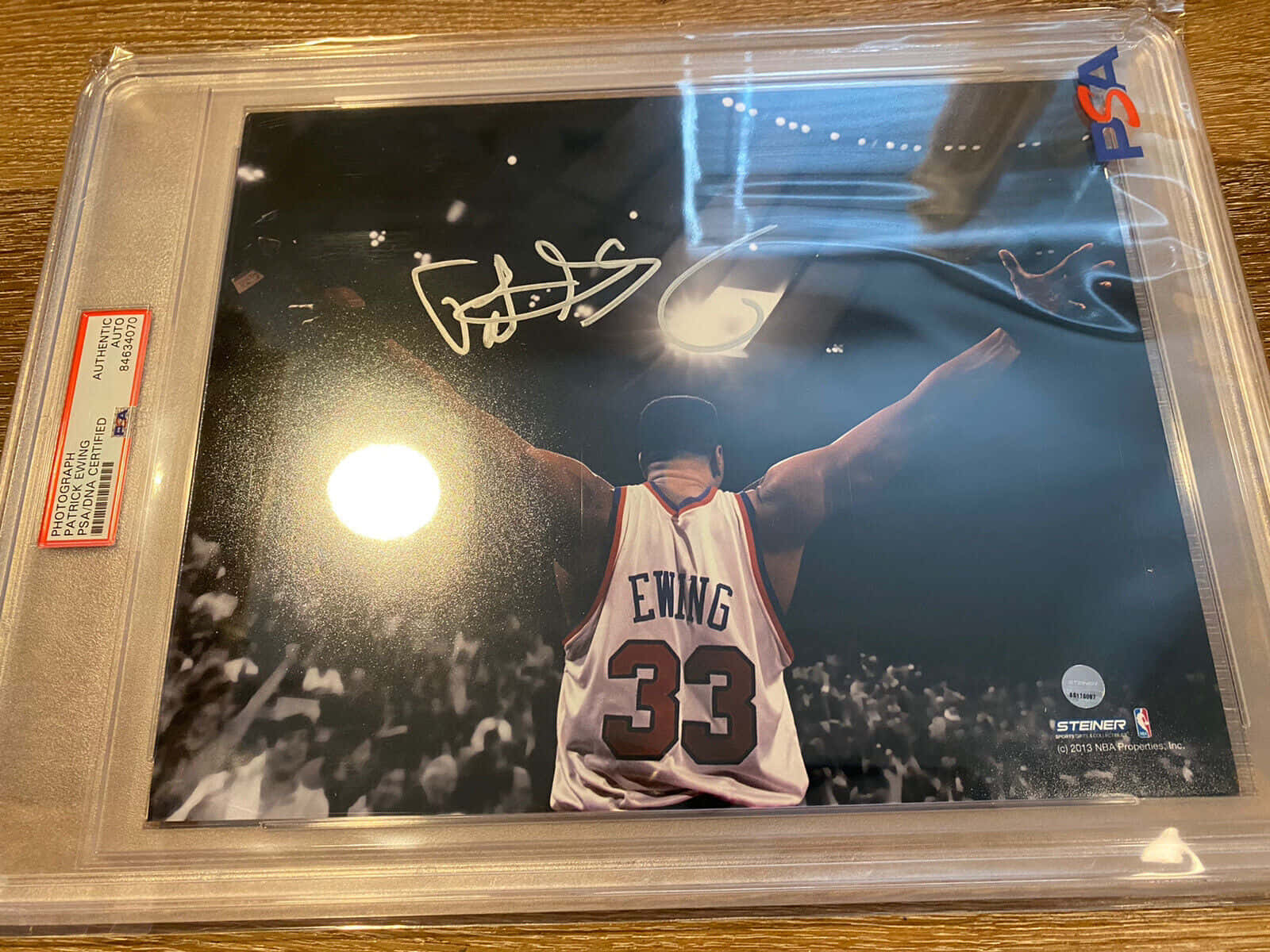 派屈克·尤因身穿尼克隊球衣，在場館中高舉雙臂慶祝，彩紙飄落。 — NBA 壁紙