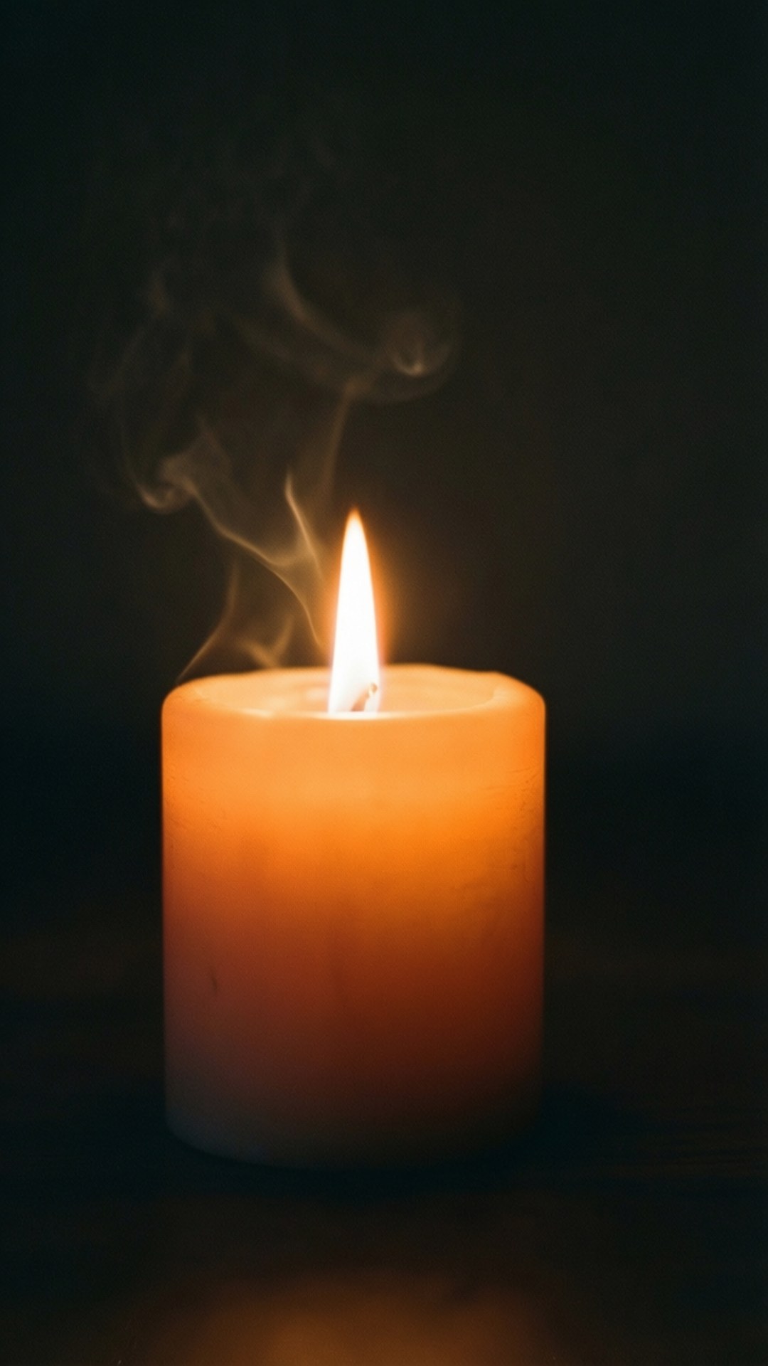 Flickering Candle 壁紙 — 一支點燃的橙色蠟燭在黑暗背景下散發出溫暖的光芒，火焰中升起縷縷煙霧。