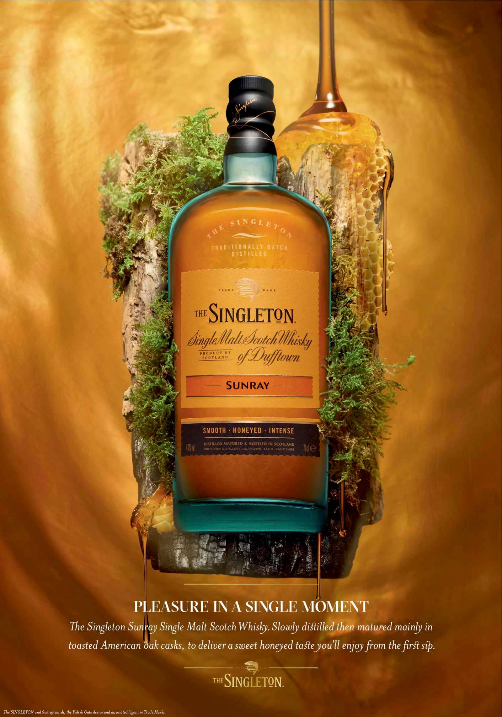 bottle 桌布 壁紙 — Singleton Sunray 威士忌酒瓶在金色背景下閃耀琥珀色光澤，置於長滿苔蘚的木頭上，旁邊有蜂巢和滴落的威士忌酒杯。