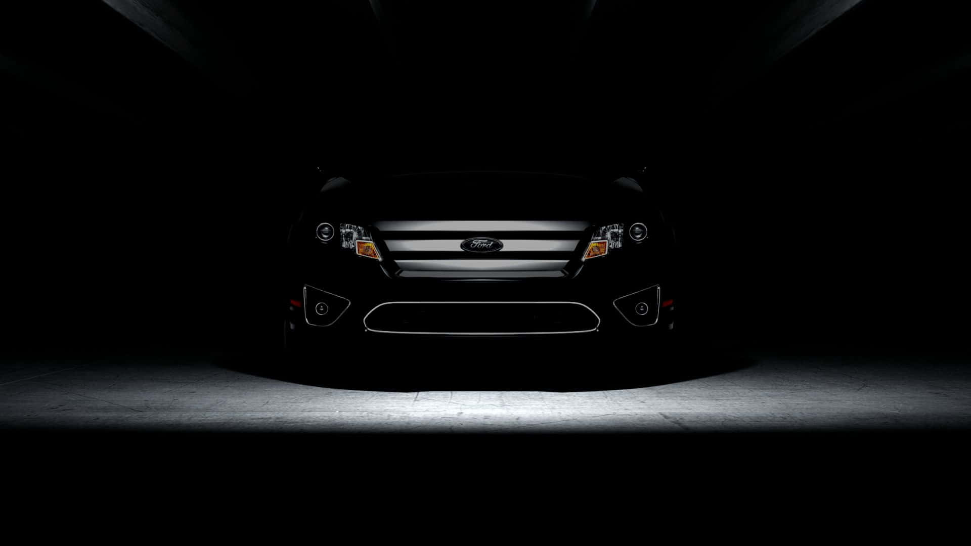 Ford Fusion 桌布 壁紙 — 一輛時尚黑色福特汽車的前部，在黑暗隧道中被聚光燈照亮，地面為混凝土。