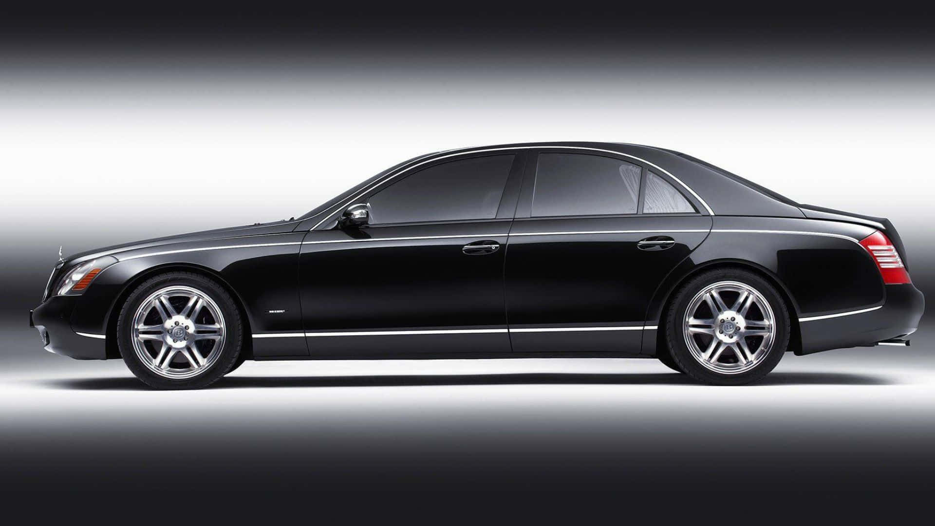 Maybach 57 桌布 壁紙 — 一輛時尚的黑色 Maybach 轎車在漸變灰色背景和工作室燈光下以側面展示。