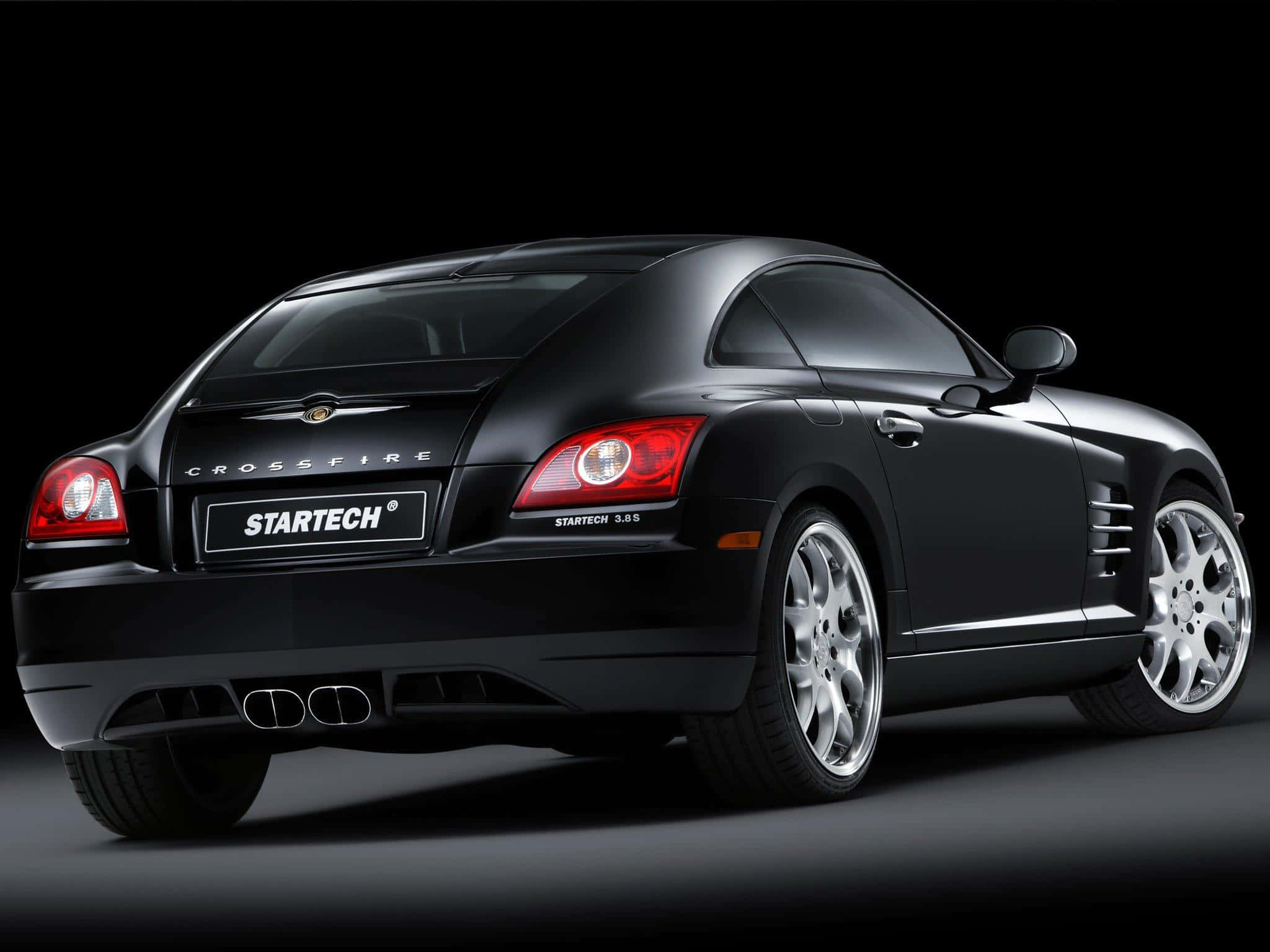 Chrysler Crossfire 桌布 壁紙 — 一輛時尚的黑色Startech Crossfire跑車，從後方四分之三角度展示，背景為深色攝影棚。