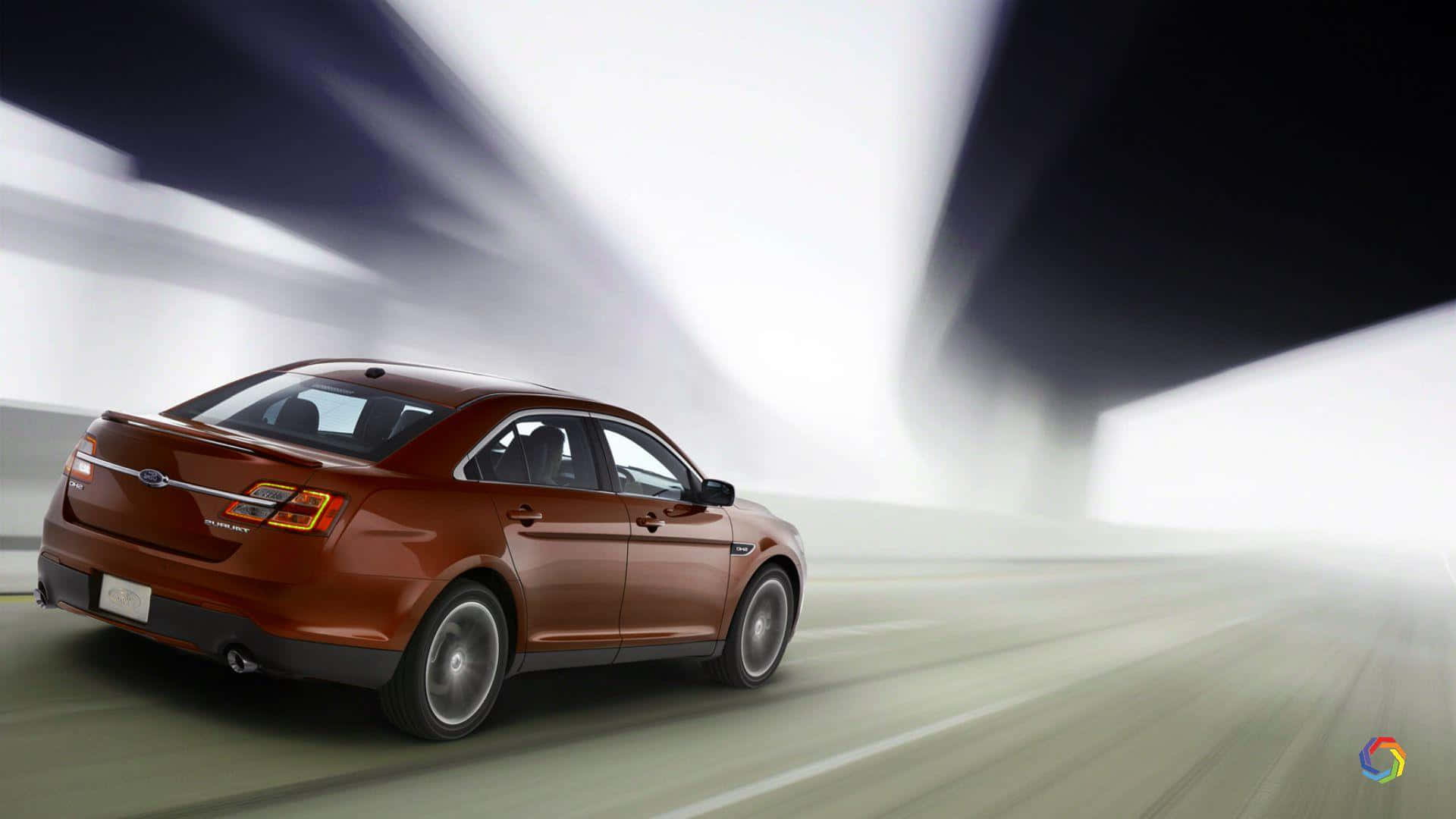 Ford Taurus 桌布 壁紙 — 一輛時尚的銅色轎車在模糊的高速公路上疾馳，天空呈現鮮明的黑白對比。