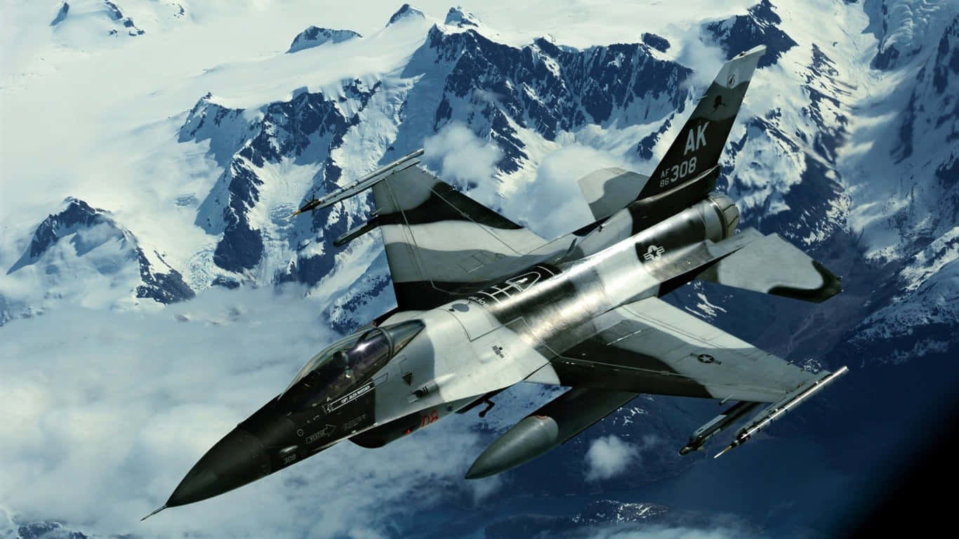 一架戰鬥機飛越積雪的山峰，穿過雲層。 — 1366X768 壁紙
