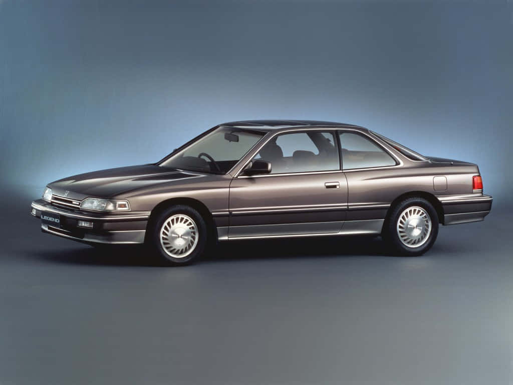 Honda Legend 桌布 壁紙 — 在工作室中展示的時尚金屬棕色凌志轎跑車，配有漸變藍色背景和柔和燈光。