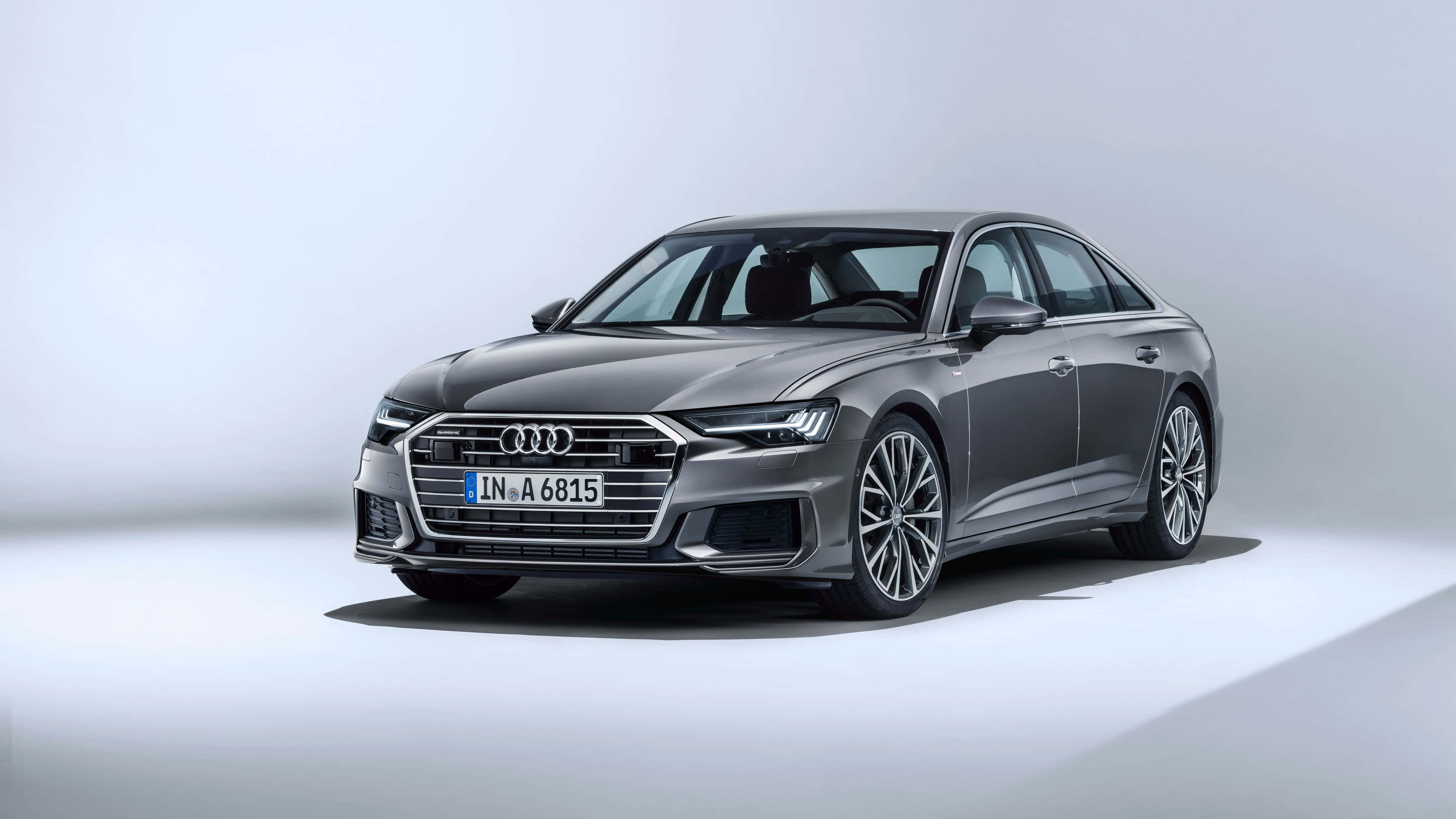 Audi A6 桌布 壁紙 — 一部時尚的銀色奧迪A6轎車在簡約的工作室中展示，配有柔和燈光和潔白背景。