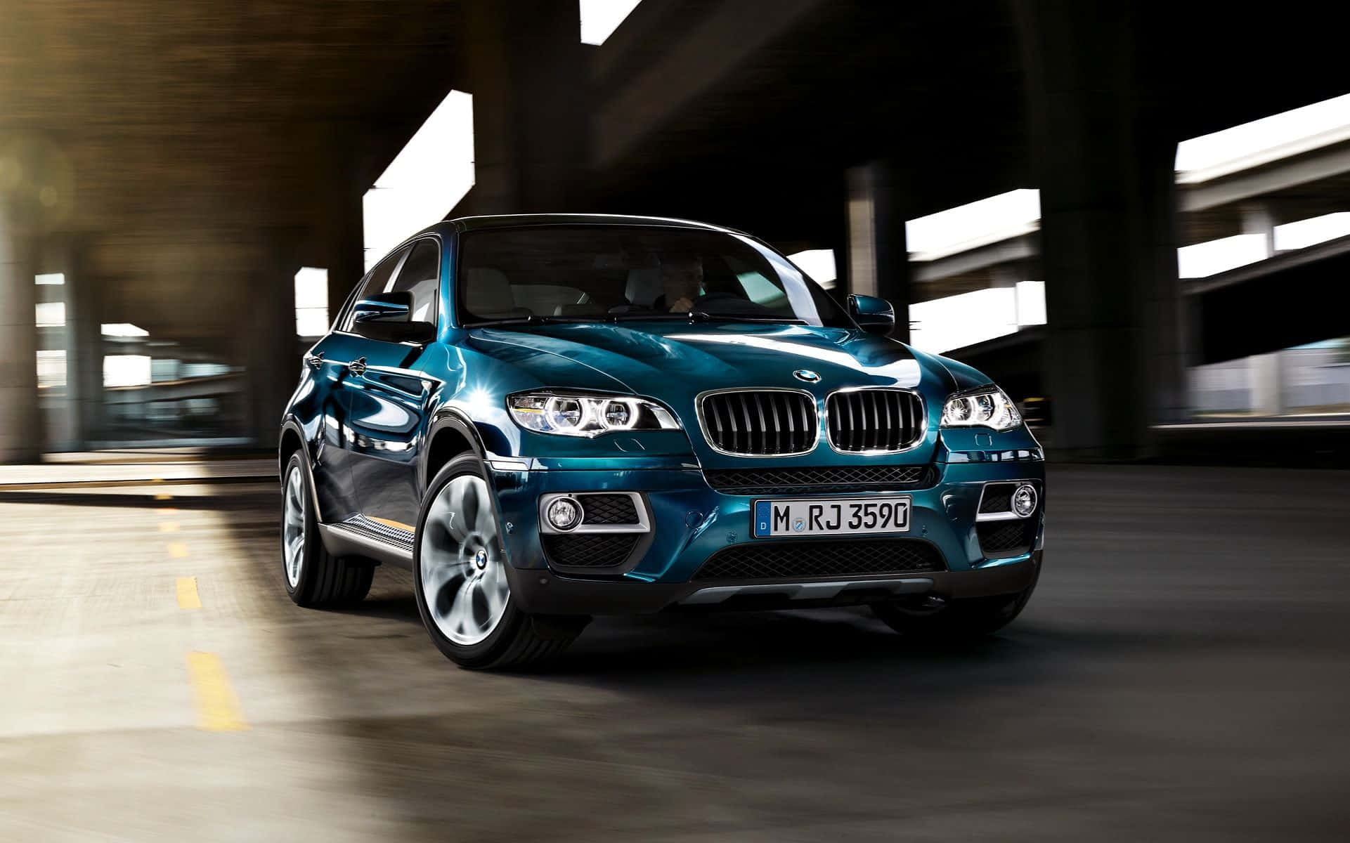 Bmw X6 桌布 壁紙 — 一台時尚的青綠色BMW X6在混凝土地下道中疾馳，動態模糊突顯其動感。