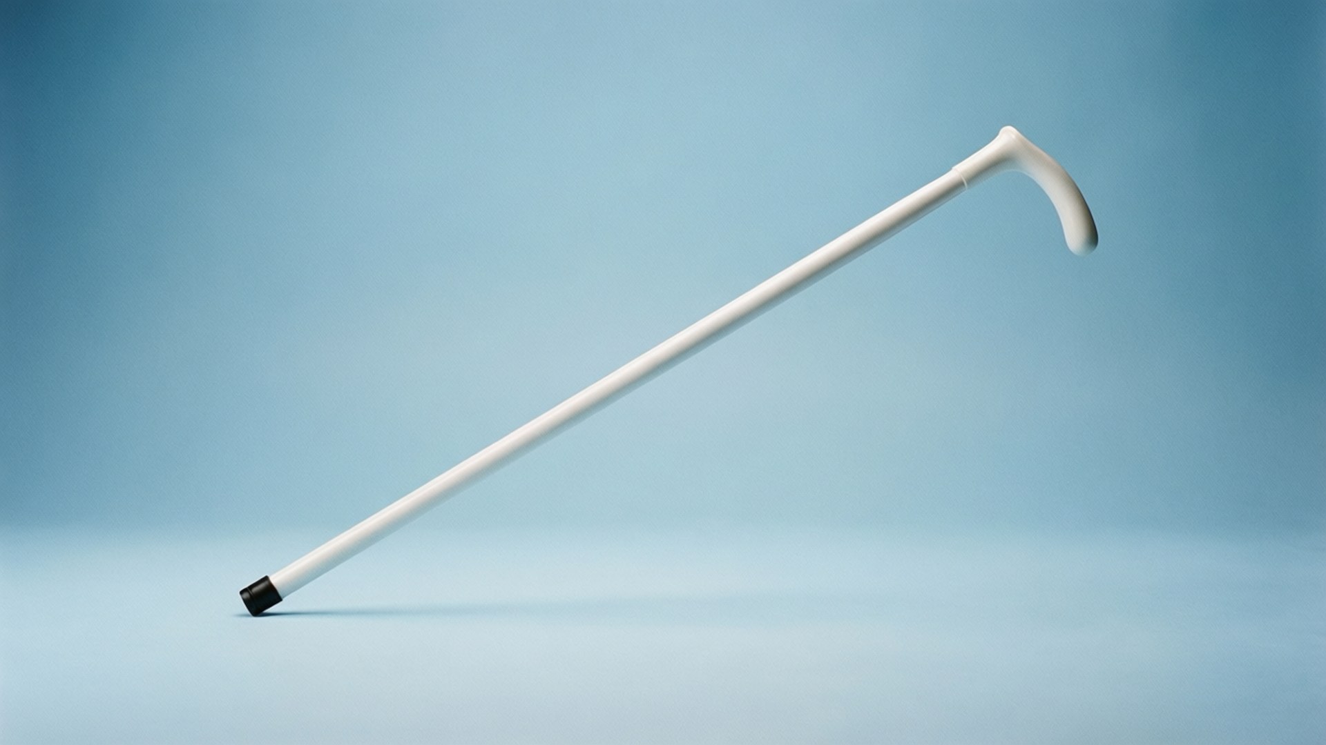White Cane Safety Day 桌布 壁紙 — 一支時尚的白色手杖，帶黑色尖端，斜靠在柔和的藍色漸變背景上。