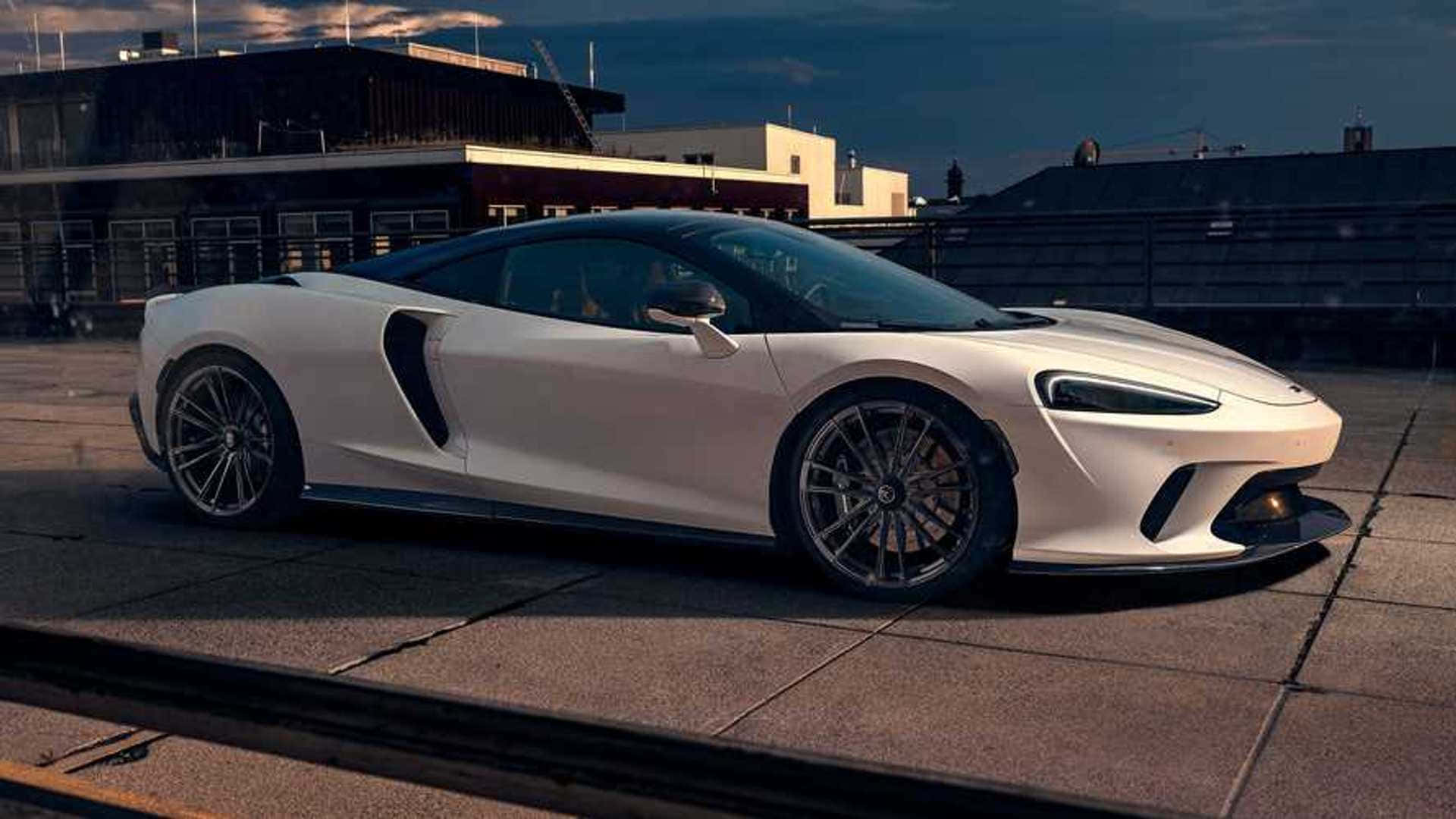 Mclaren Gt 桌布 壁紙 — 一輛時尚的白色跑車在黃昏時停泊在屋頂上，背景是城市建築。