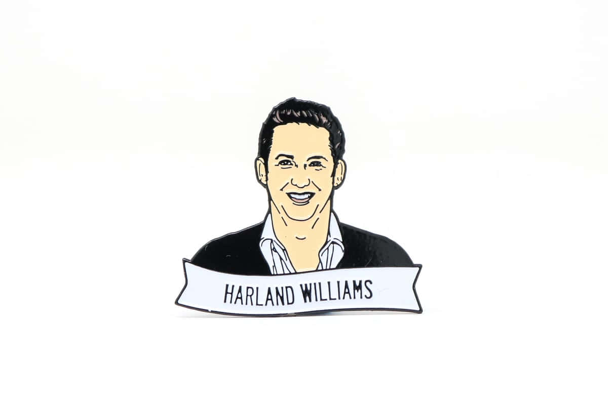  壁紙 — 一個微笑的Harland Williams琺瑯徽章，其肖像下方有一個白色橫幅，背景為純白色。