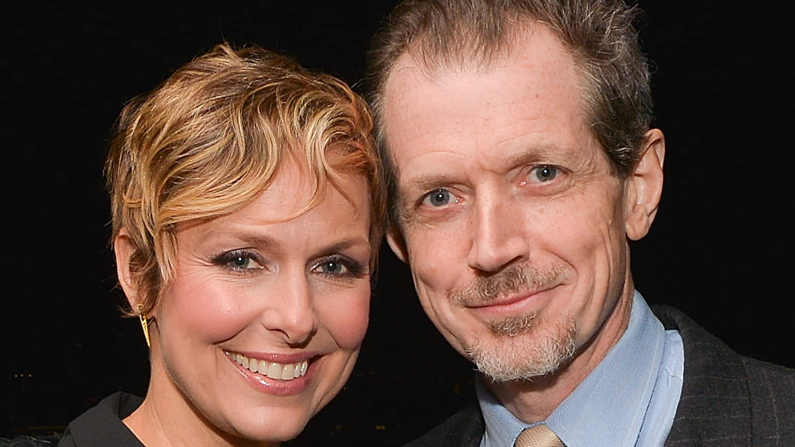 Melora Hardin 桌布 壁紙 — 一位微笑的男士和女士在深色背景前緊密地擺姿勢，拍攝正式肖像。