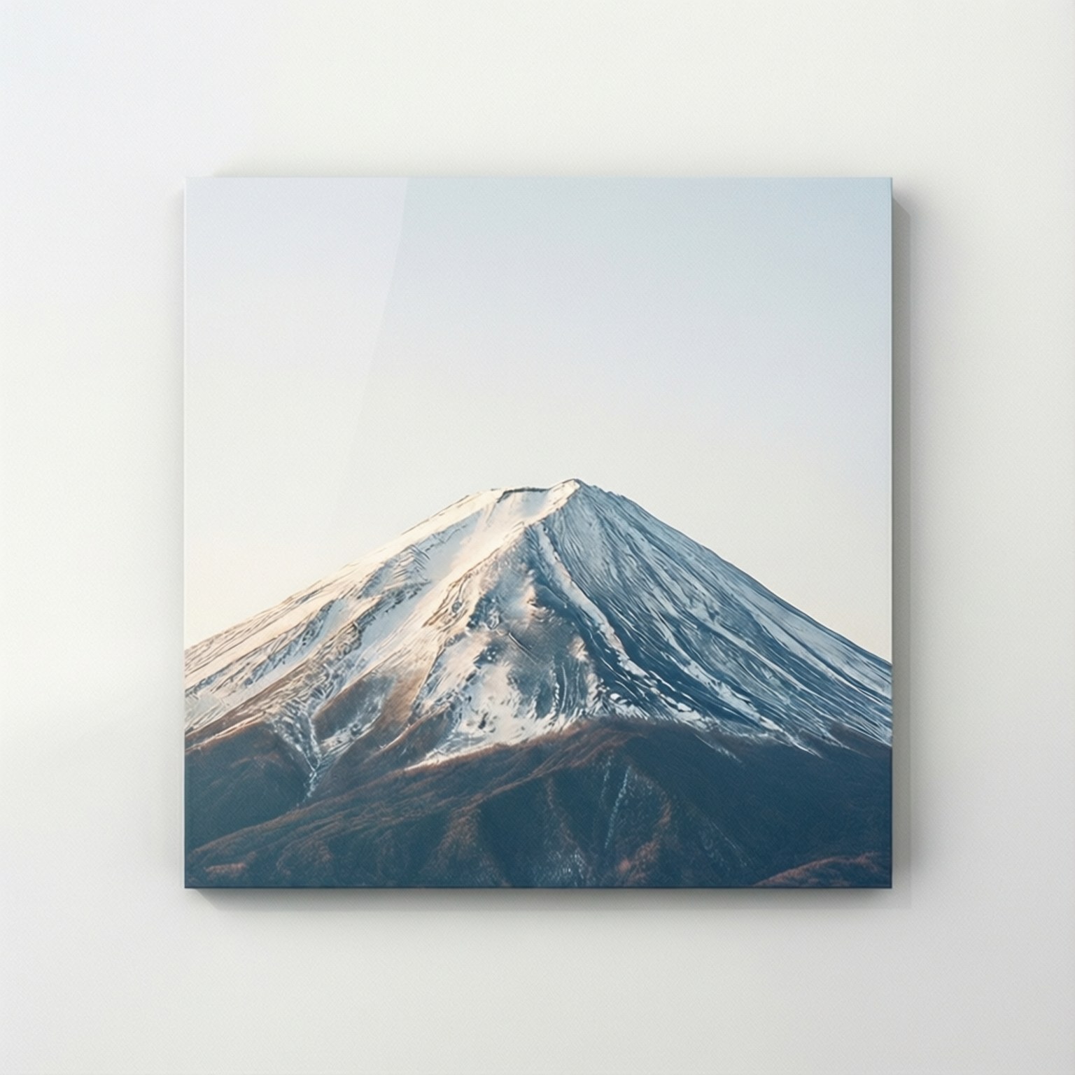 Minimalist Peak Square 壁紙 — 一座白雪覆蓋的山峰，崎嶇的山坡，柔和的光線映襯著蒼白的天空。