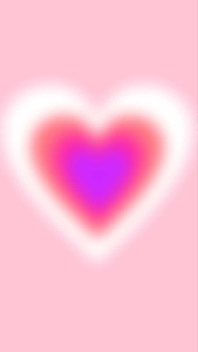 Pink Heart Aura 桌布 壁紙 — 一顆柔和發光的心形，帶有粉紅色和紫色漸變，在粉彩粉紅色背景上散發溫暖。