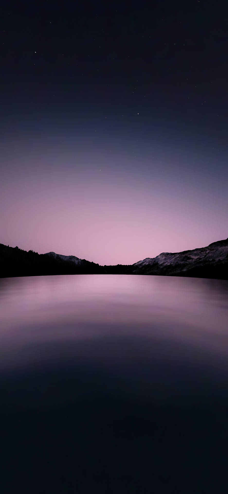 平靜的湖面倒映著紫色的暮色天空和星空下的山巒剪影 — iPhone X 壁紙