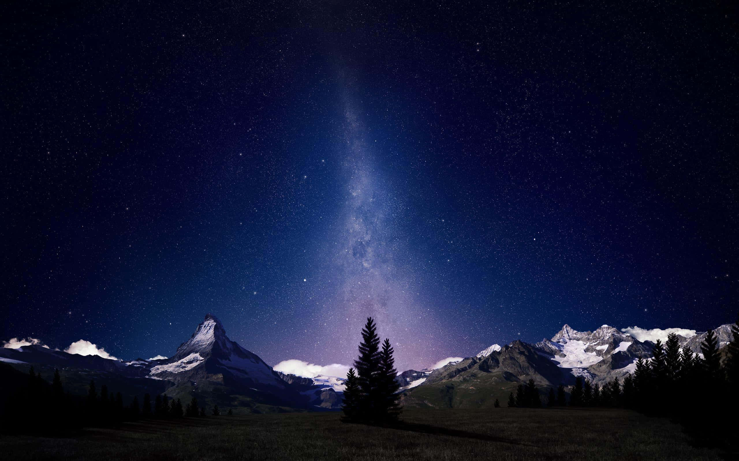 Night Time 桌布 壁紙 — 星空之夜，銀河拱跨雪覆山巒與孤松剪影。
