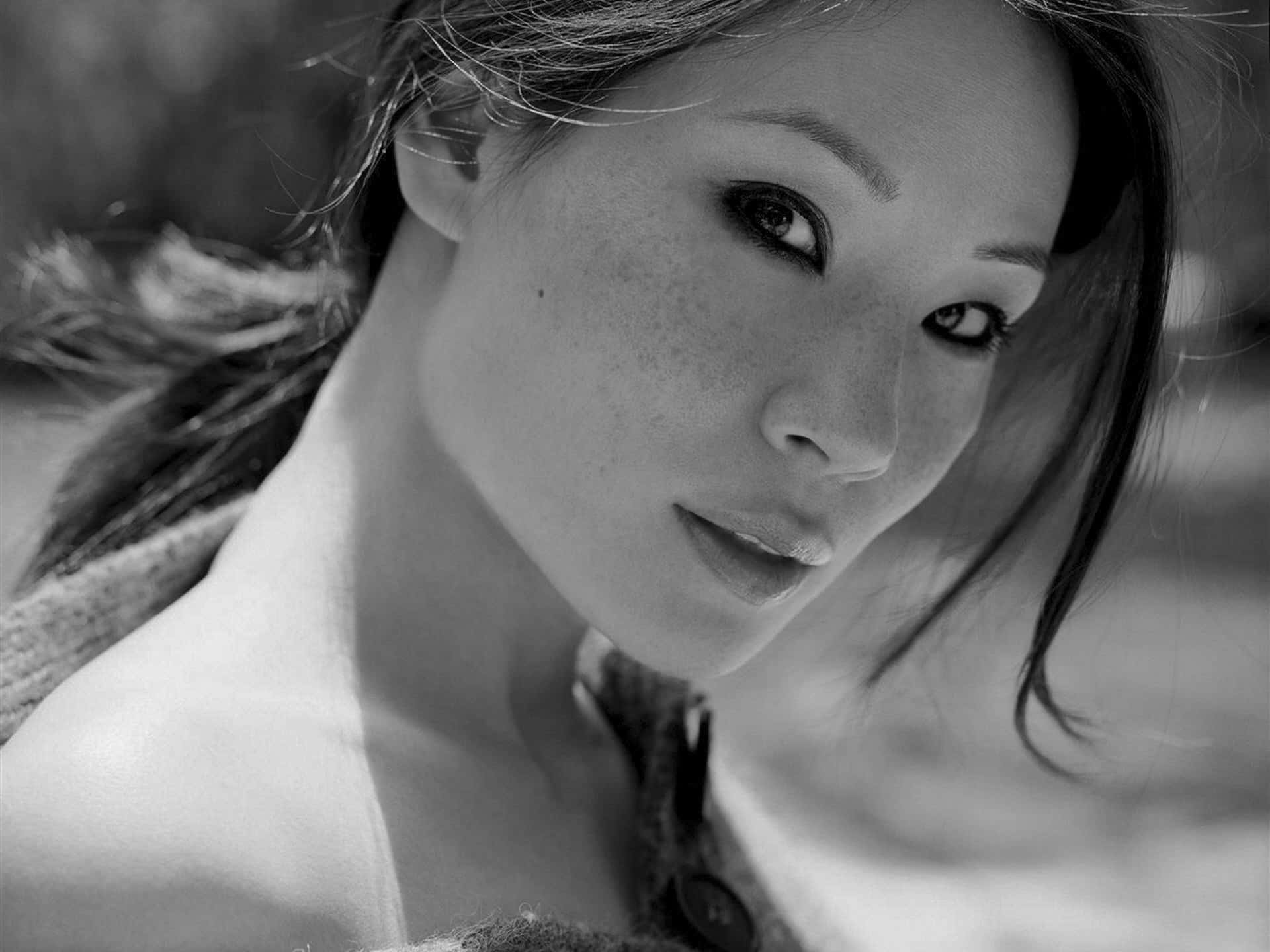 一位有雀斑的女性在黑白肖像中直視鏡頭。 — 台灣 壁紙