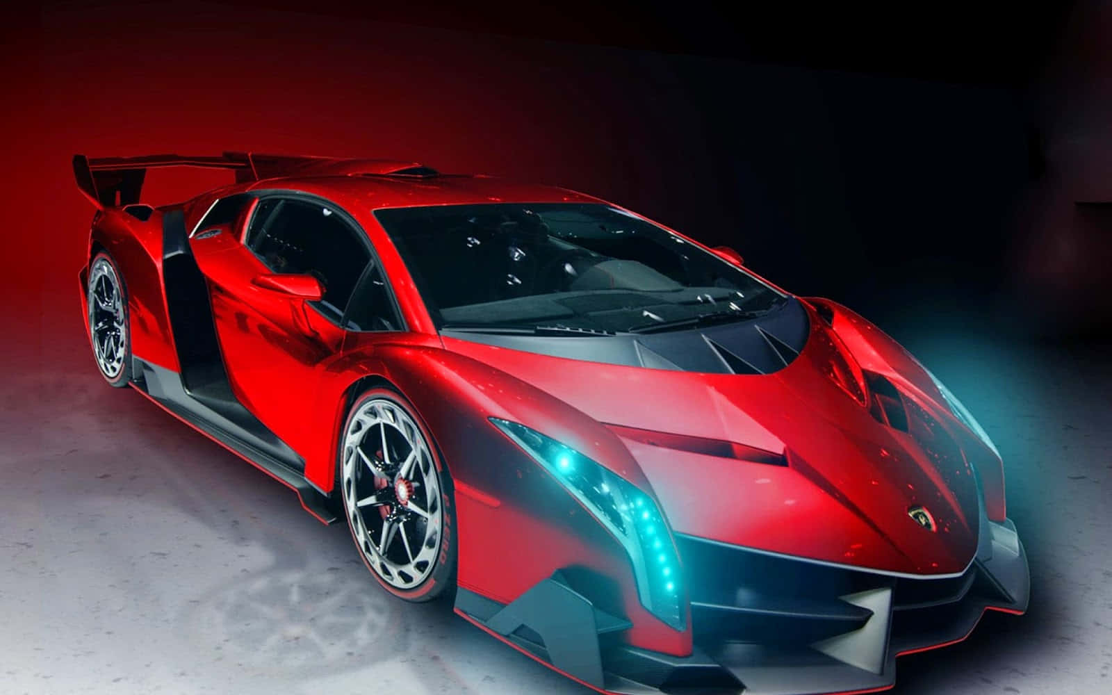 Lamborghini Veneno 桌布 壁紙 — 一輛引人注目的紅色藍寶堅尼跑車，配備發光的藍色車頭燈和戲劇性的尾翼，在強烈的紅色和藍色工作室燈光下展示。