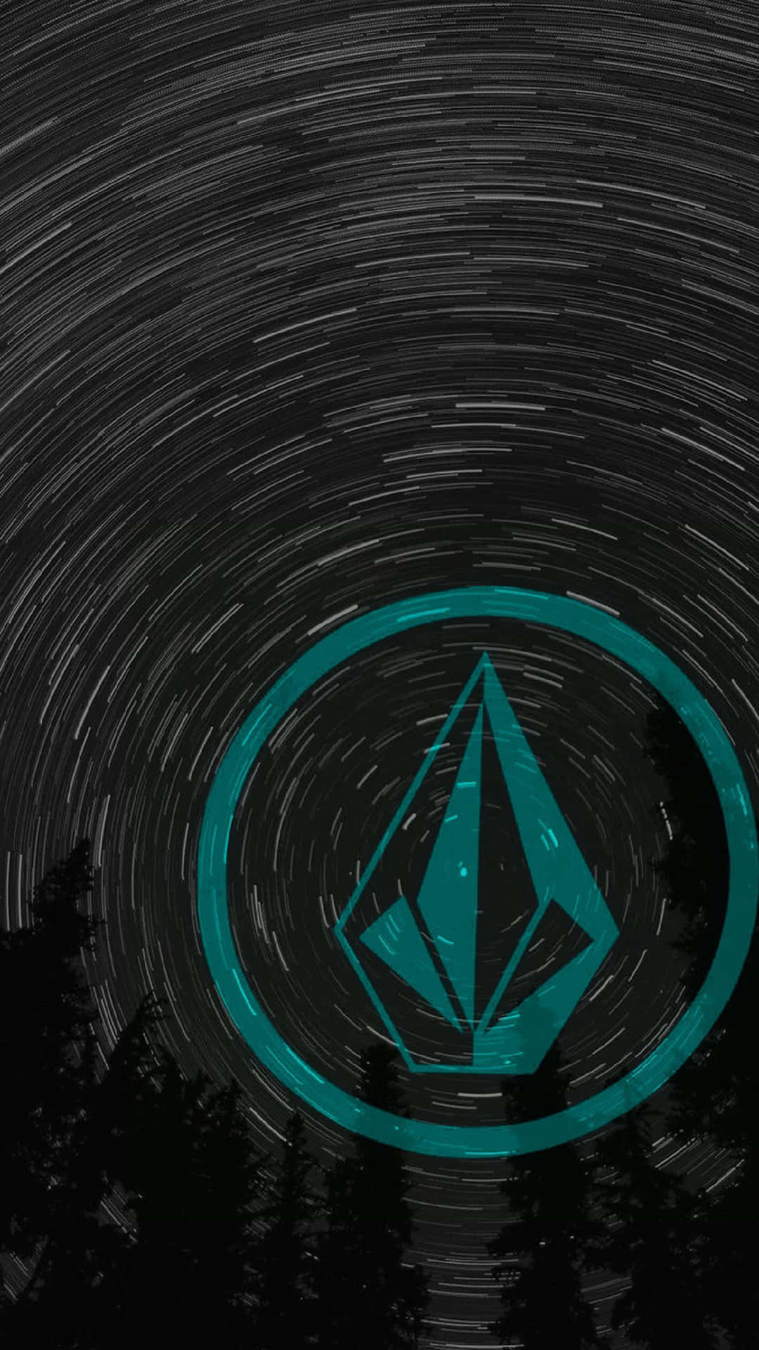  壁紙 — 一個青色的 Volcom 標誌在由黑暗松樹框住的漩渦星軌夜空下發光。