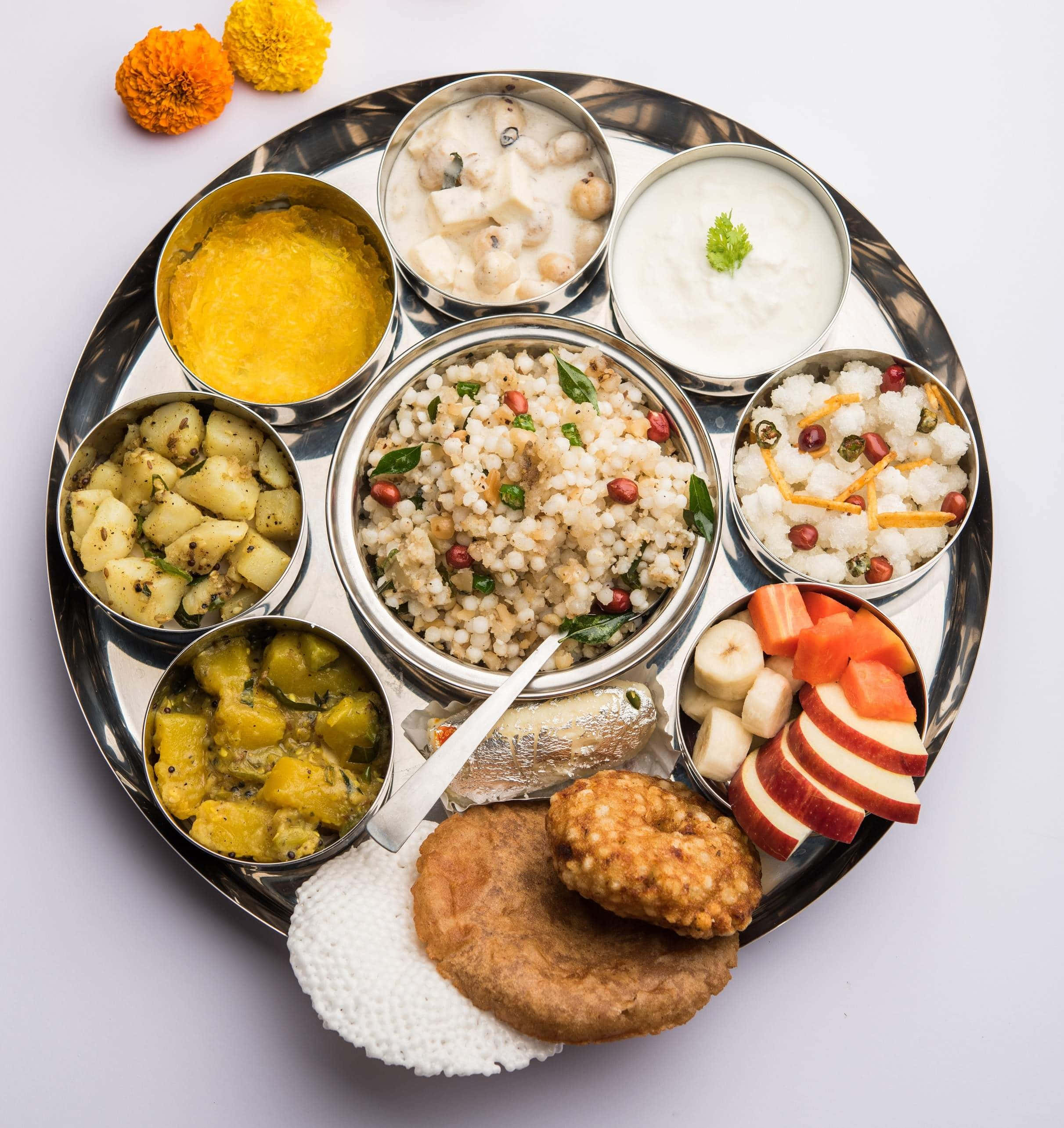 Thali 桌布 壁紙 — 一個充滿活力的印度塔利，金屬托盤上擺放著各種色彩繽紛的菜餚和新鮮水果。