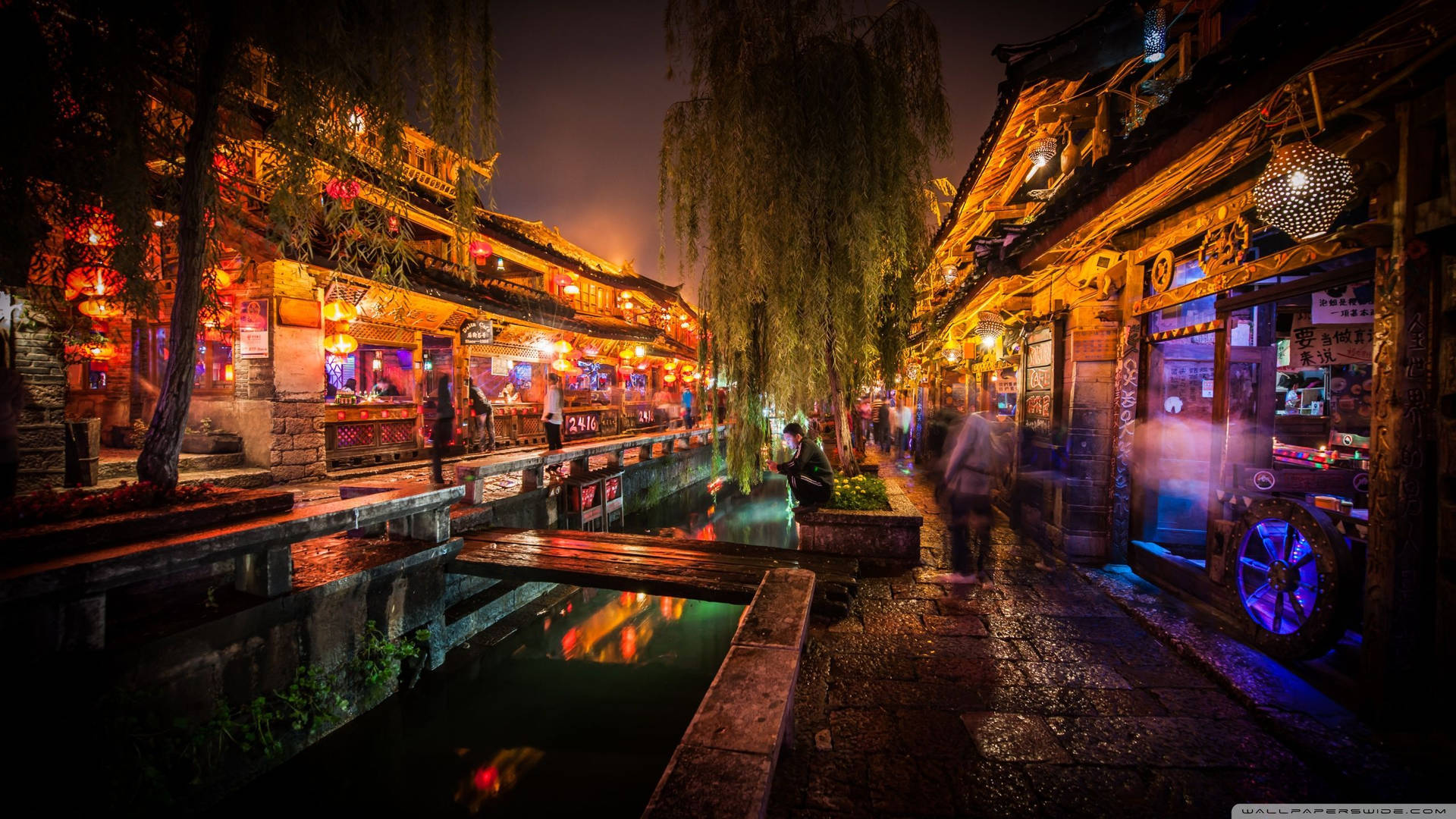 傳統中國小鎮的夜間運河步道，有發光的燈籠和濕漉漉的石板路。 — 日本櫻花 壁紙