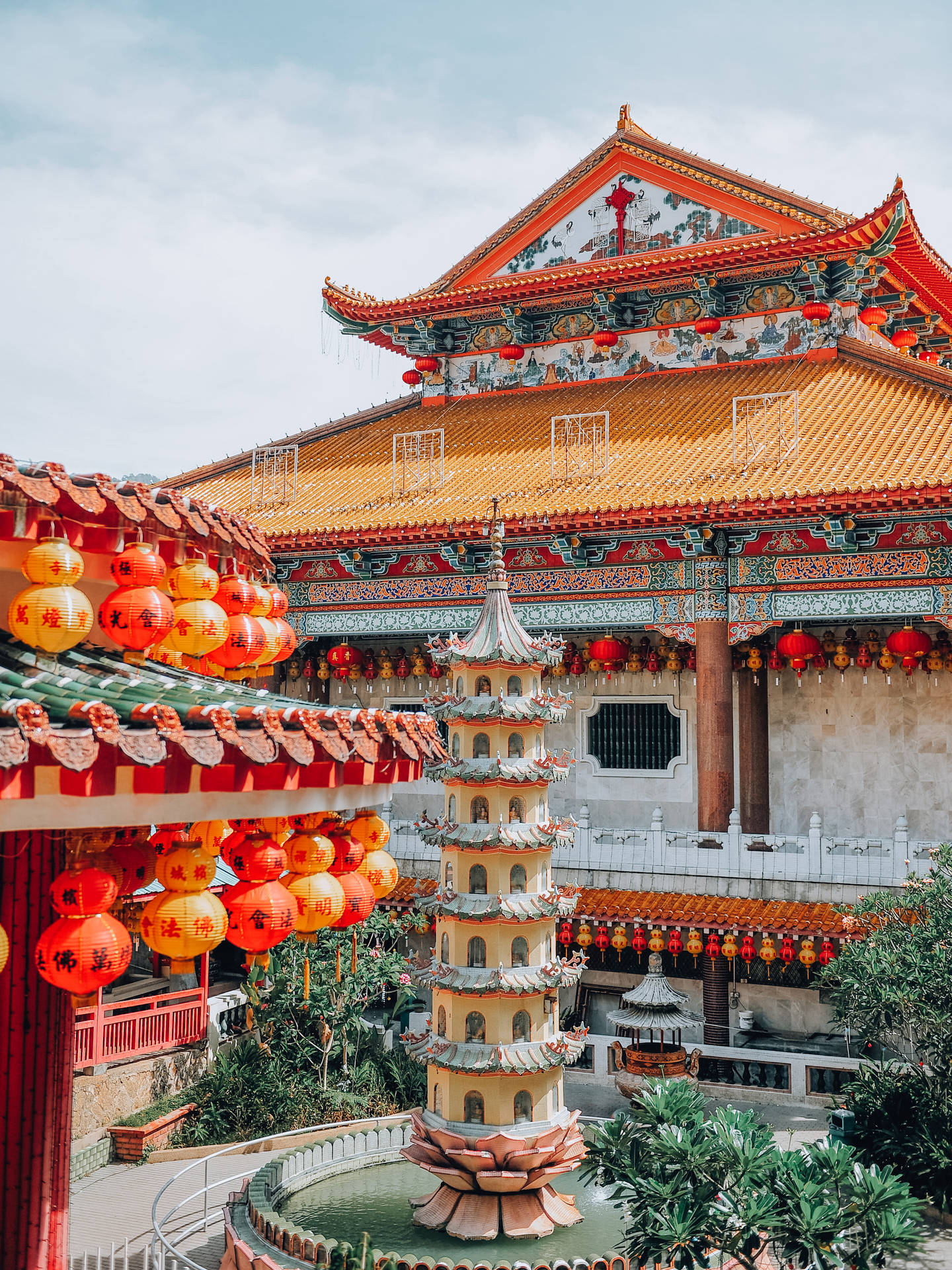 色彩繽紛的中國寺廟庭院，有紅色燈籠和中央的寶塔噴泉。 — 春節 壁紙
