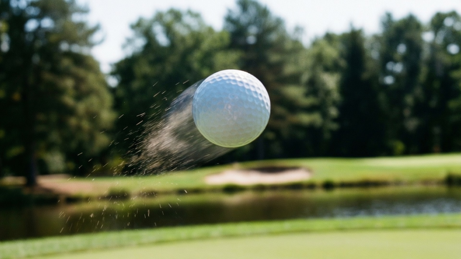 Ball in Flight 壁紙 — 一個白色高爾夫球在運動中爆炸，背景是模糊的綠色球道和森林。