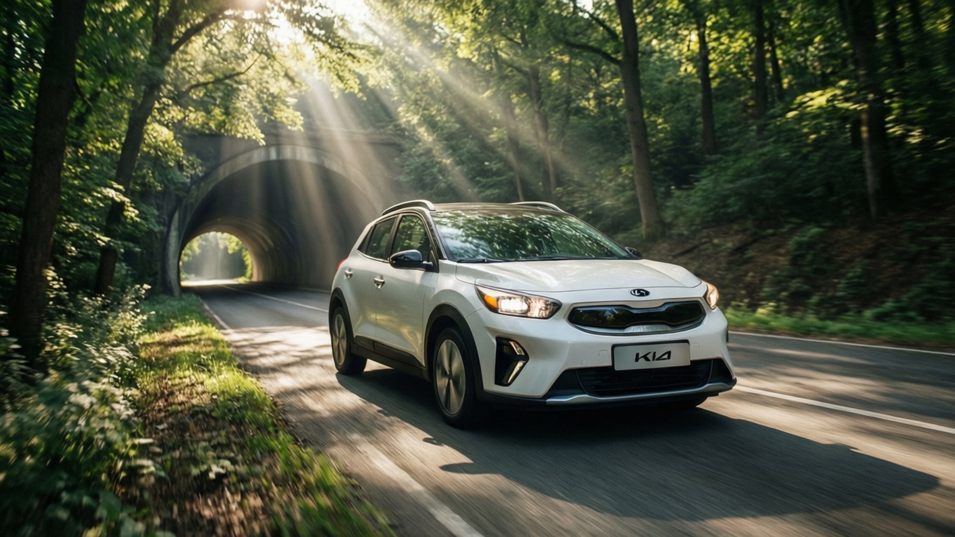 Niro Green Path 壁紙 — 一輛白色Kia SUV在森林道路上行駛，陽光穿過樹木射向石頭隧道。