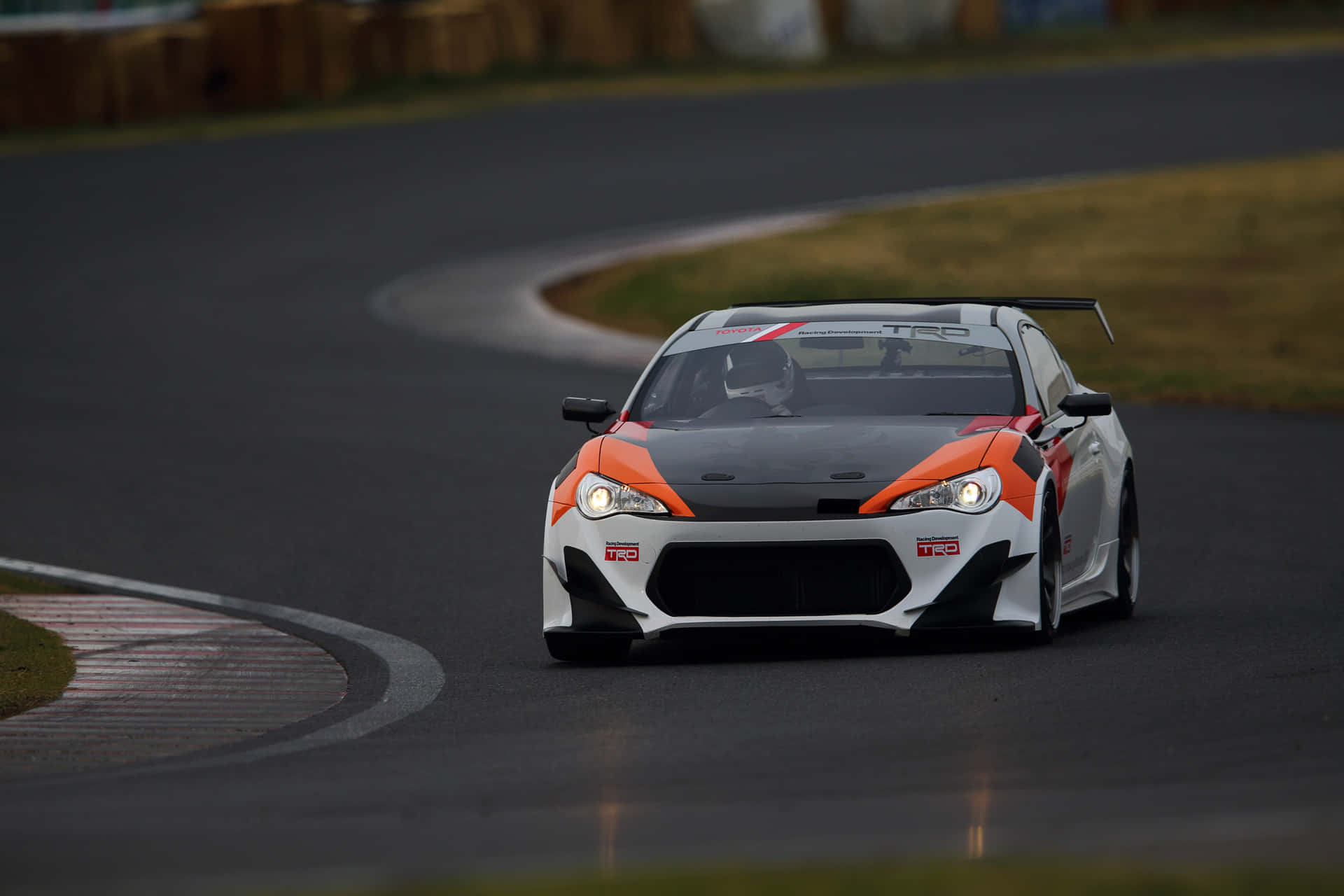 賽車在黃昏時分在濕滑的賽道彎道上飛馳。 — Toyota Supra 壁紙