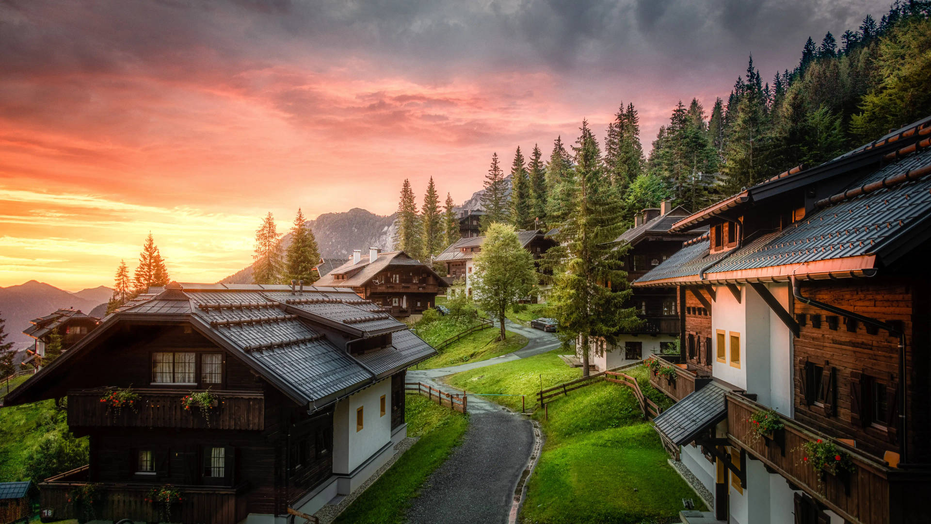日落時分的山村，木屋被松樹環繞。 — 山景 壁紙