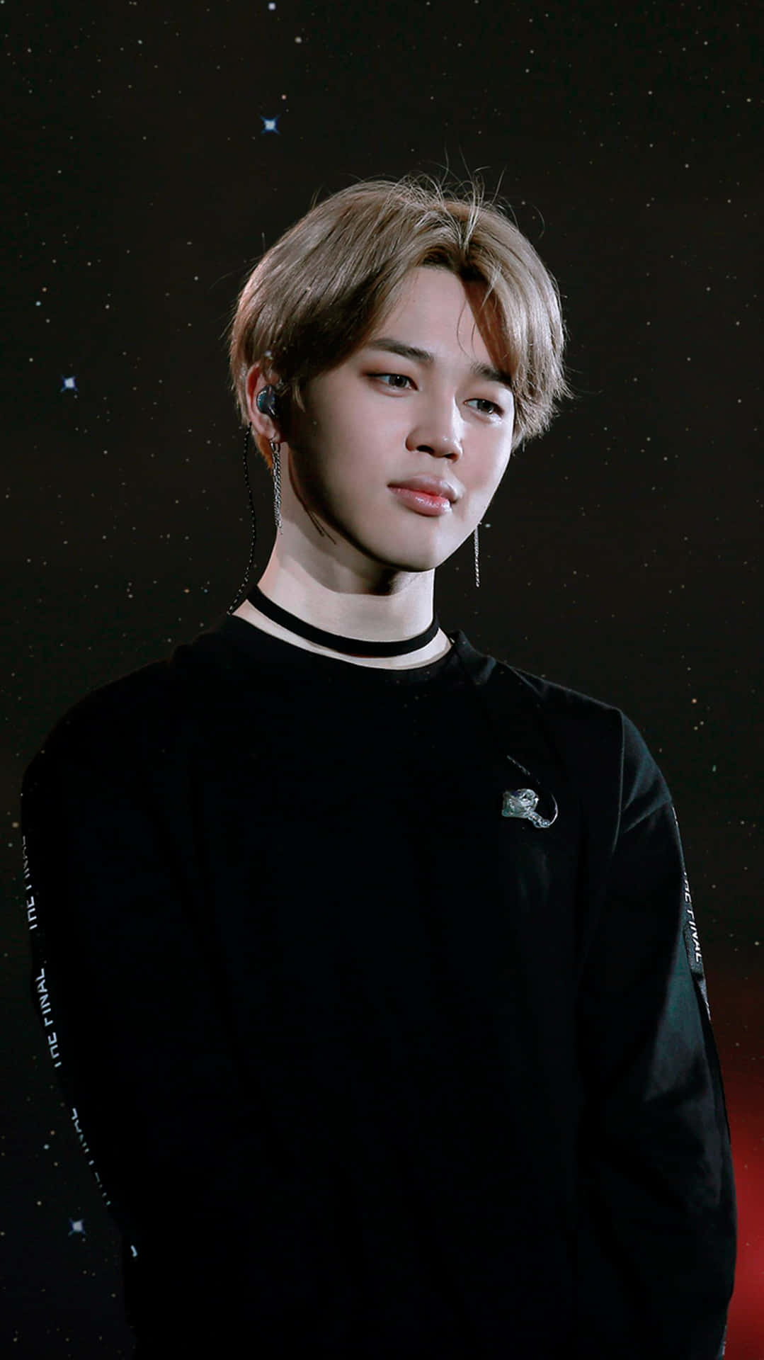 身穿黑色服裝的年輕男子，背景是繁星點點的夜空和紅色光芒。 — Bts 壁紙