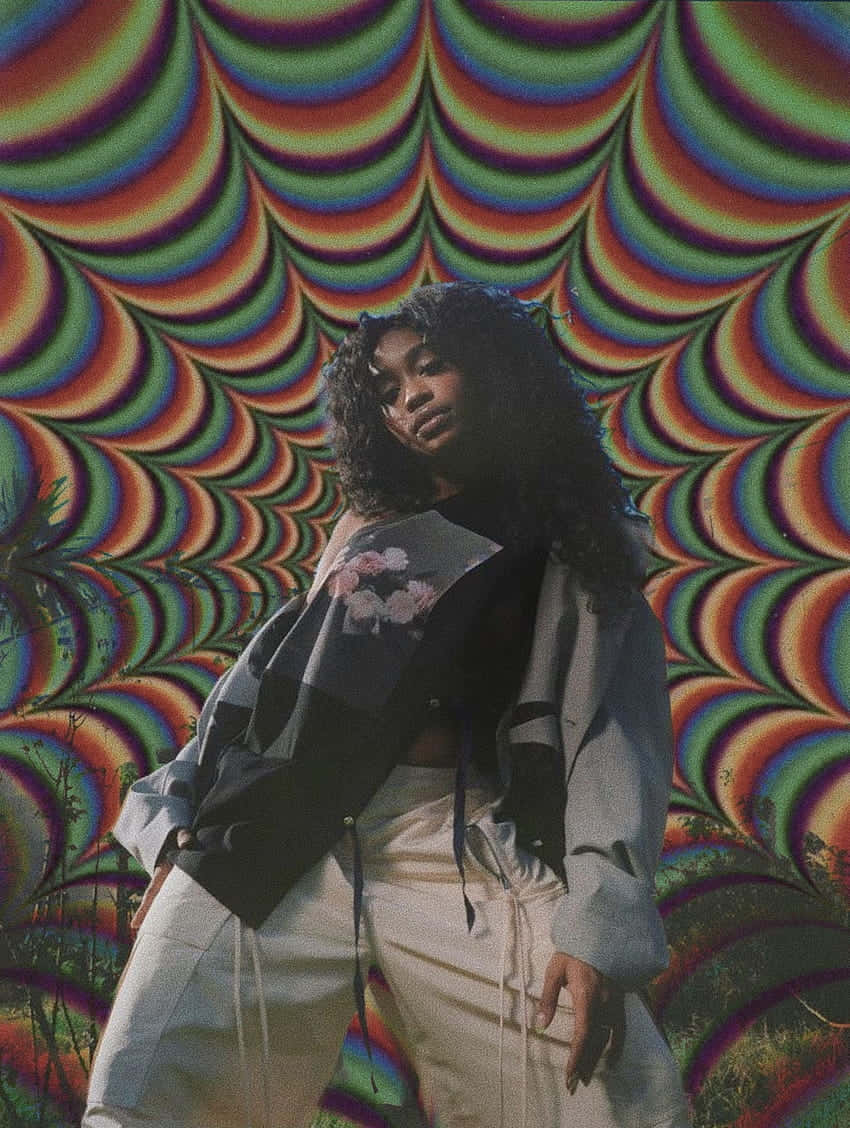  壁紙 — 一位年輕的捲髮女性自信地站在充滿活力的迷幻彩虹波浪圖案背景前。