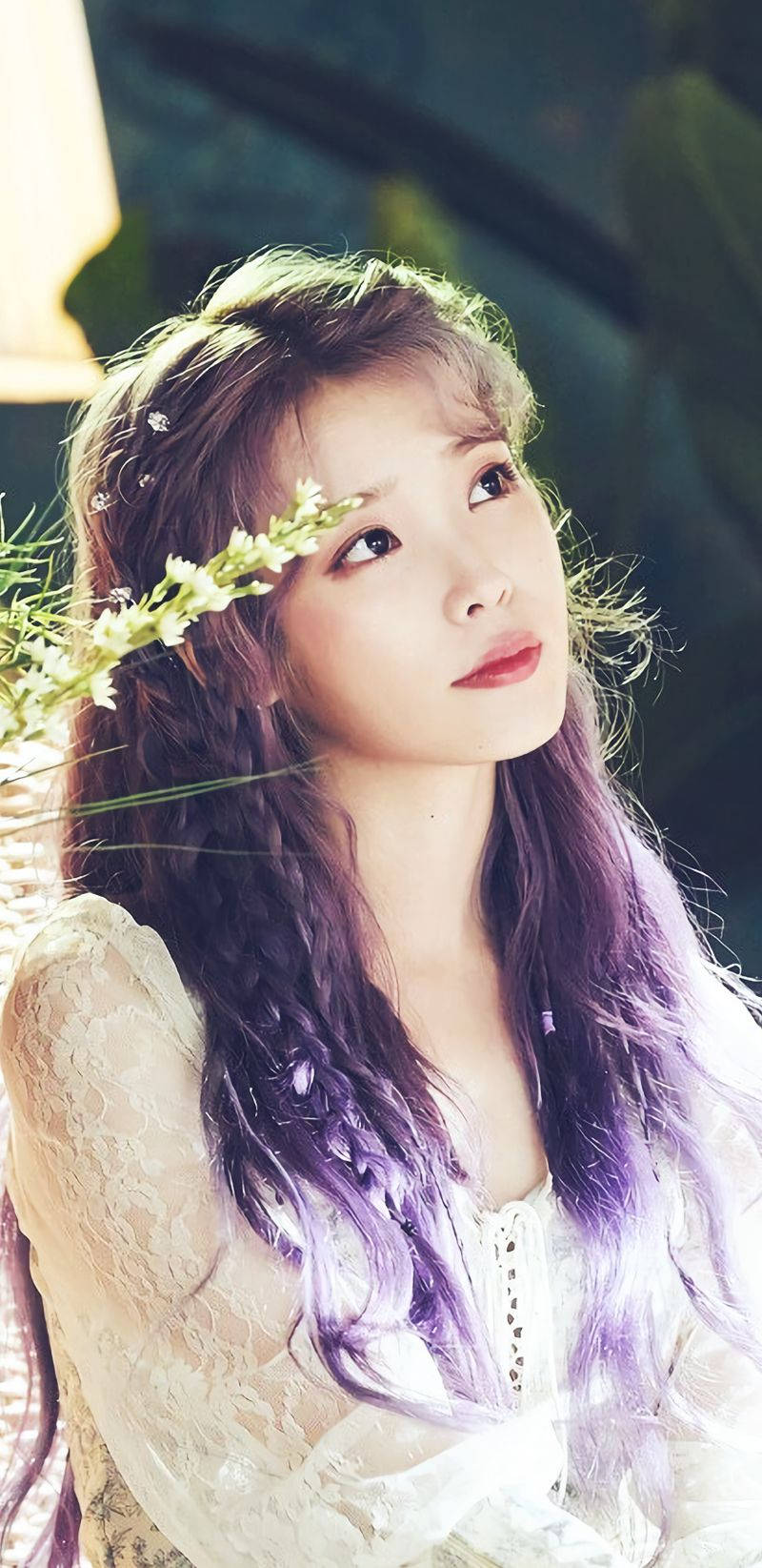 擁有紫色頭髮和花冠的年輕女性在柔和光線中向上凝視。 — K Pop 壁紙
