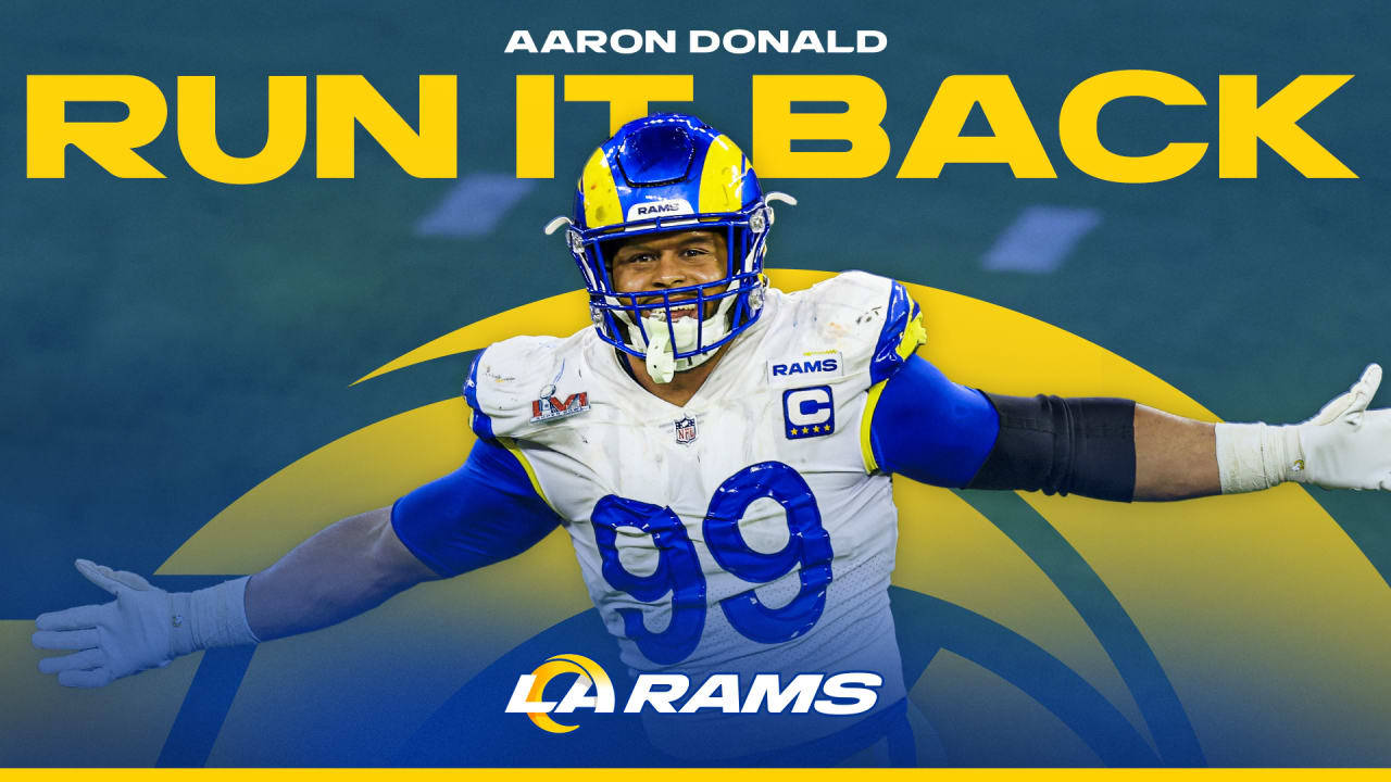 足球 桌布 壁紙 — Aaron Donald 身穿洛杉磯公羊隊球衣，在充滿活力的藍黃色背景上張開雙臂慶祝。