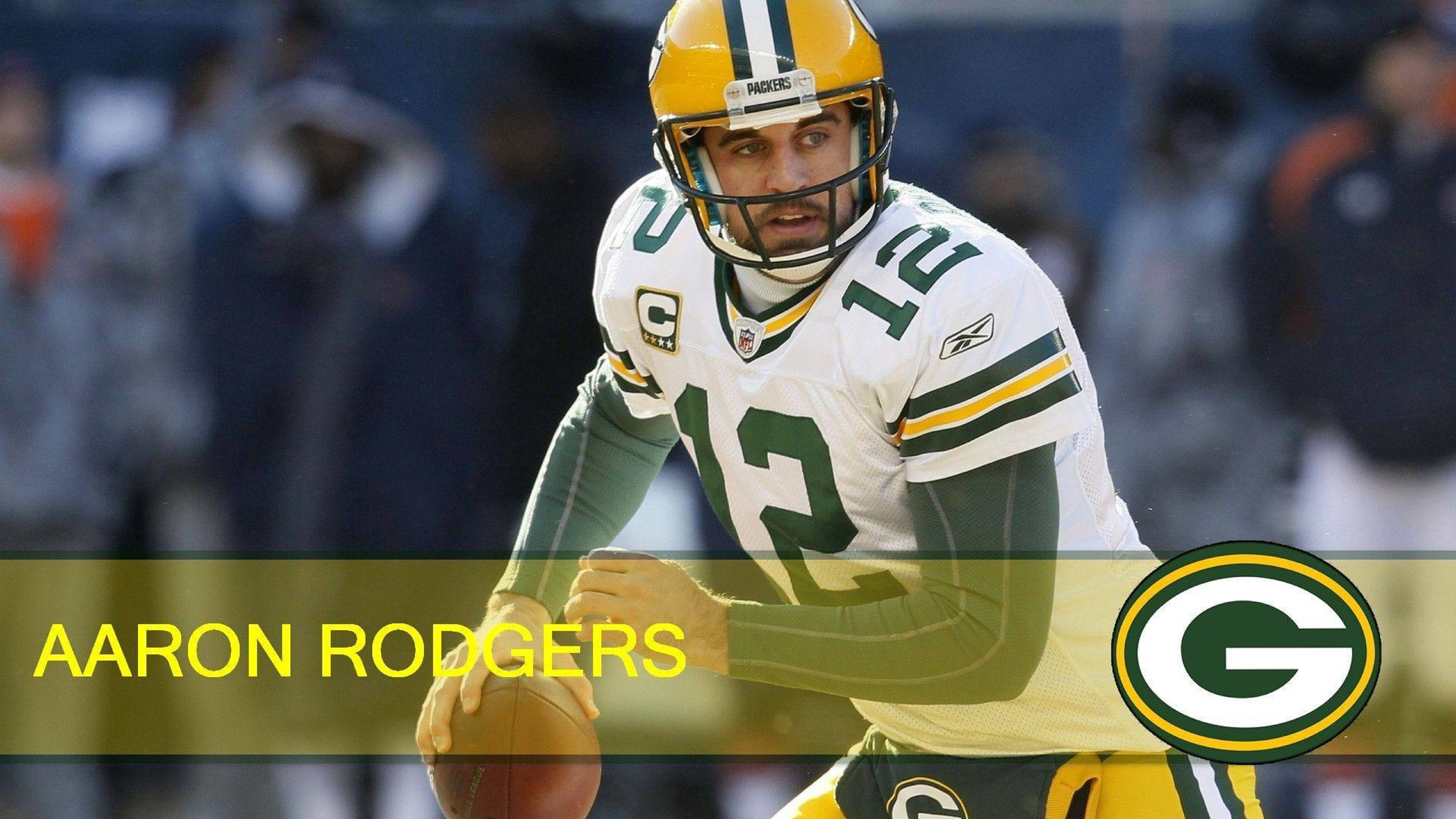 Aaron Rodgers 桌布 壁紙 — Aaron Rodgers 身穿綠灣包裝工隊制服，在球場燈光下準備在比賽中投擲橄欖球。