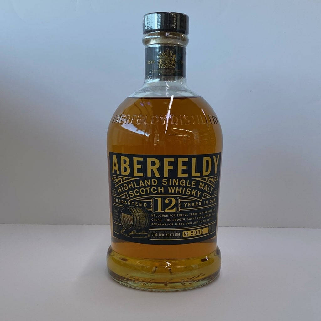 Drink 桌布 壁紙 — Aberfeldy 12年高地單一麥芽蘇格蘭威士忌酒瓶，帶有琥珀色液體和黑色標籤，居中放置在白色表面上。