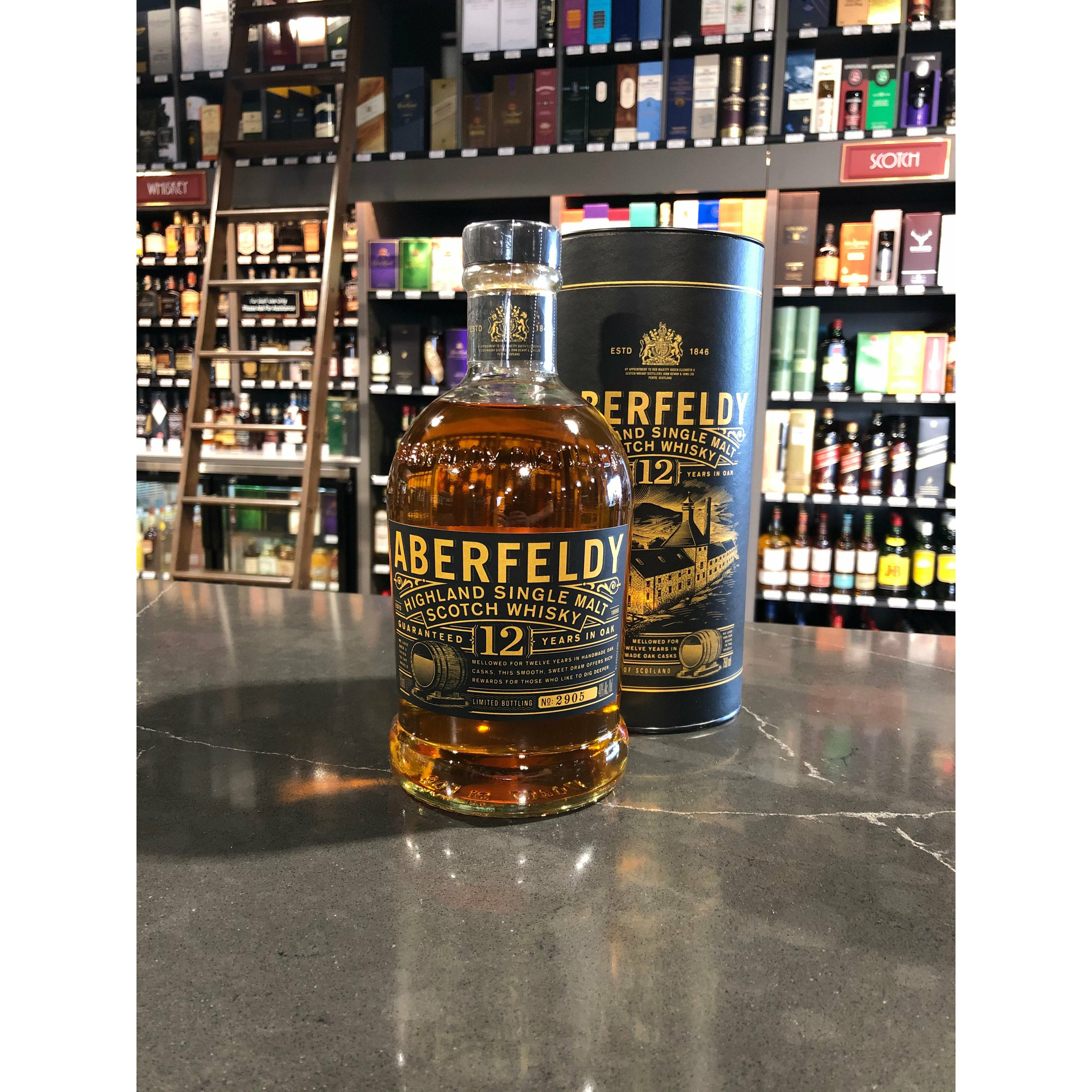 Drink 桌布 壁紙 — Aberfeldy 12年高地單一麥芽蘇格蘭威士忌酒瓶和禮盒放在一家貨品齊全的酒類商店的深色大理石檯面上。