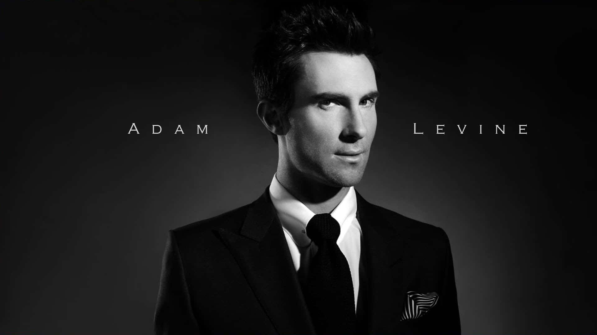 Adam Levine 桌布 壁紙 — Adam Levine 身穿剪裁俐落的西裝，口袋裡放著方巾，在深色漸變背景前望向鏡頭外的黑白肖像。